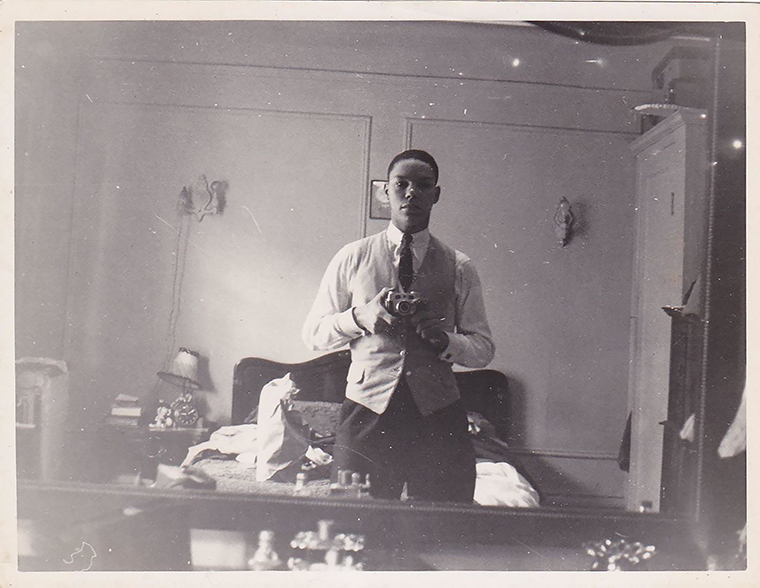 A young Powell takes a photo of himself in a mirror. 