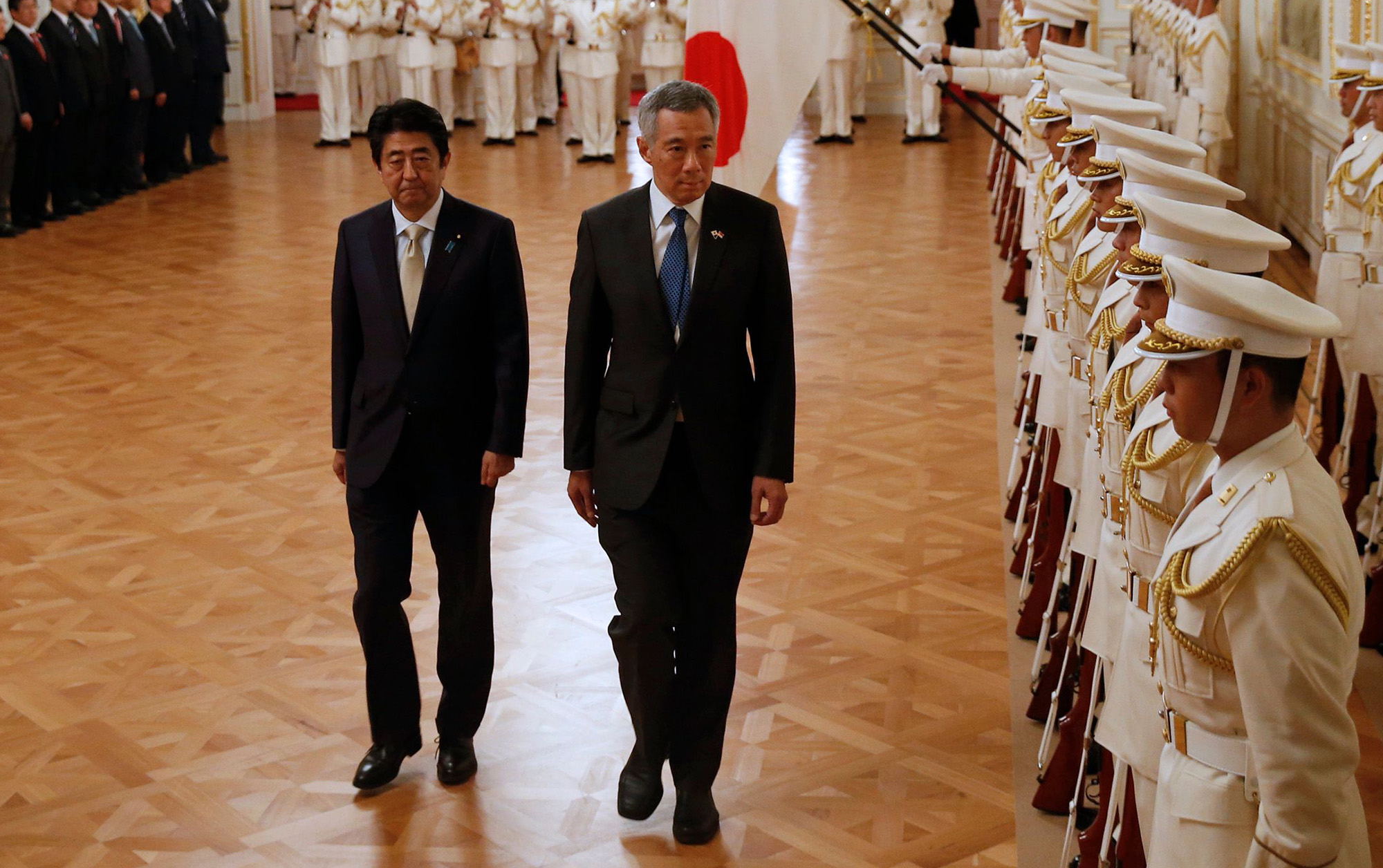 Japan's Prime Minister Shinzo Abe and Singapore's Prime Minister Lee Hsien Loong attend a welcoming ceremony hosted by Abe at the state guest house in Tokyo on September 28, 2016. 