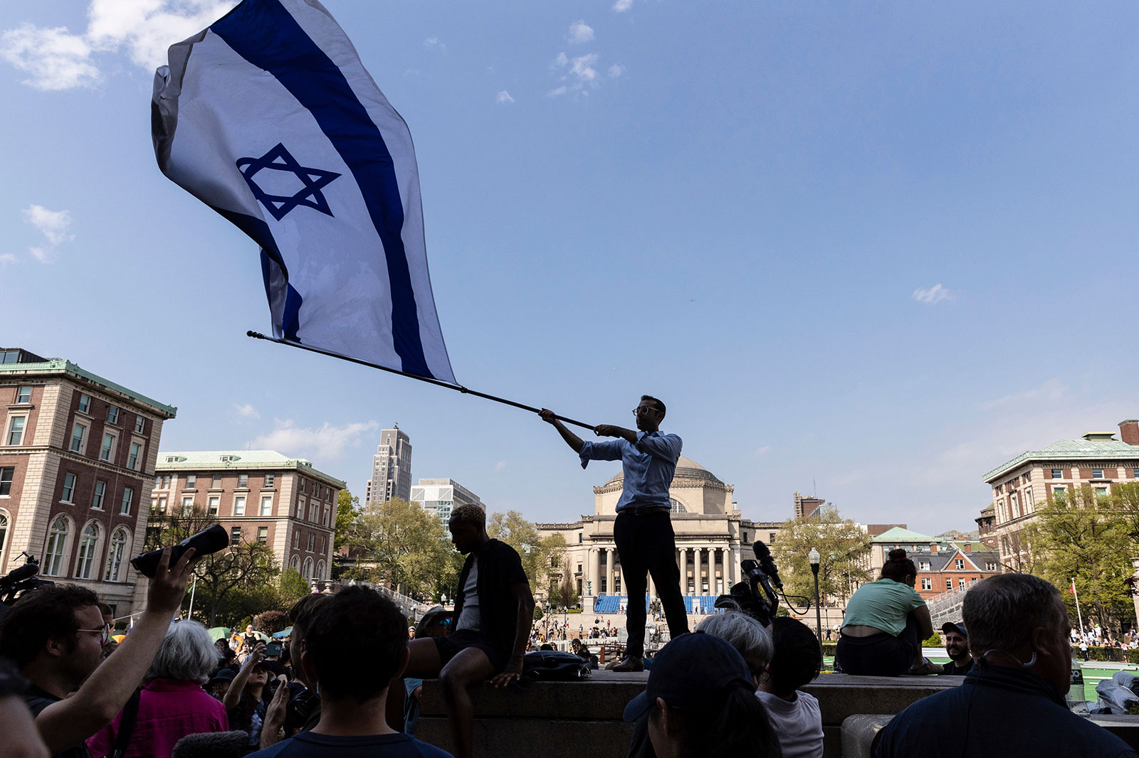 Columbia sophomore, David Lederer, waves a large flag of Israel outside the student protest encampment on the Columbia University campus, on Monday, April 29,in New York. 