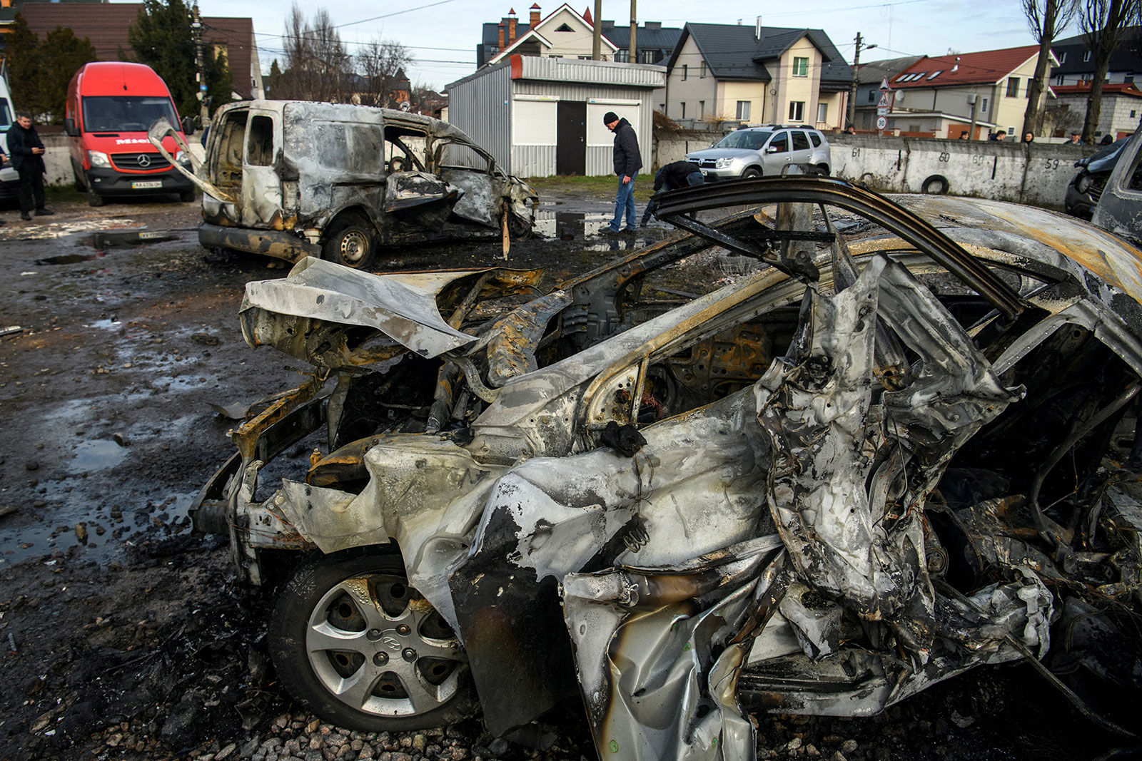 A man walks next to a car destroyed during a Russian missile and drone strike in Kyiv on Friday. 