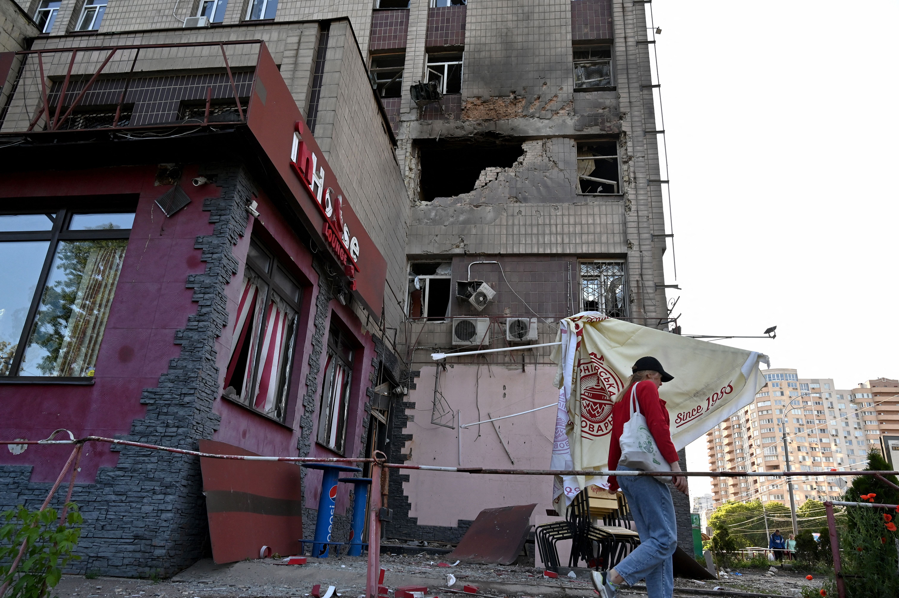 A local resident walks past a partially destroyed residential building after a massive Russian drones strike mainly targeting the Ukrainian capital, in Kyiv, on May 28.