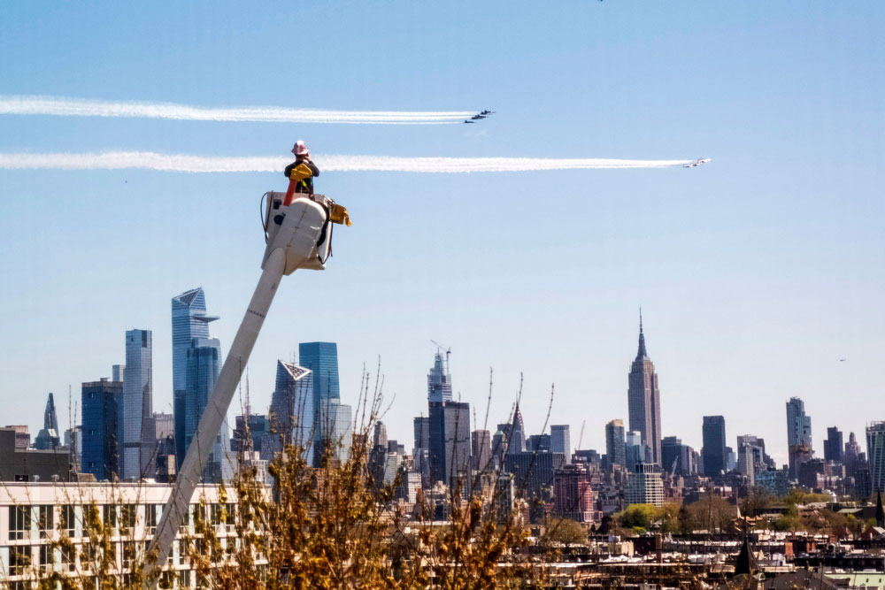 A utility worker watches the US Navy's Blue Angels and the US Air Force's Thunderbirds conduct "a collaborative salute" to honor those battling the coronavirus pandemic with a flyover of New York and New Jersey, on Tuesday, April 28.