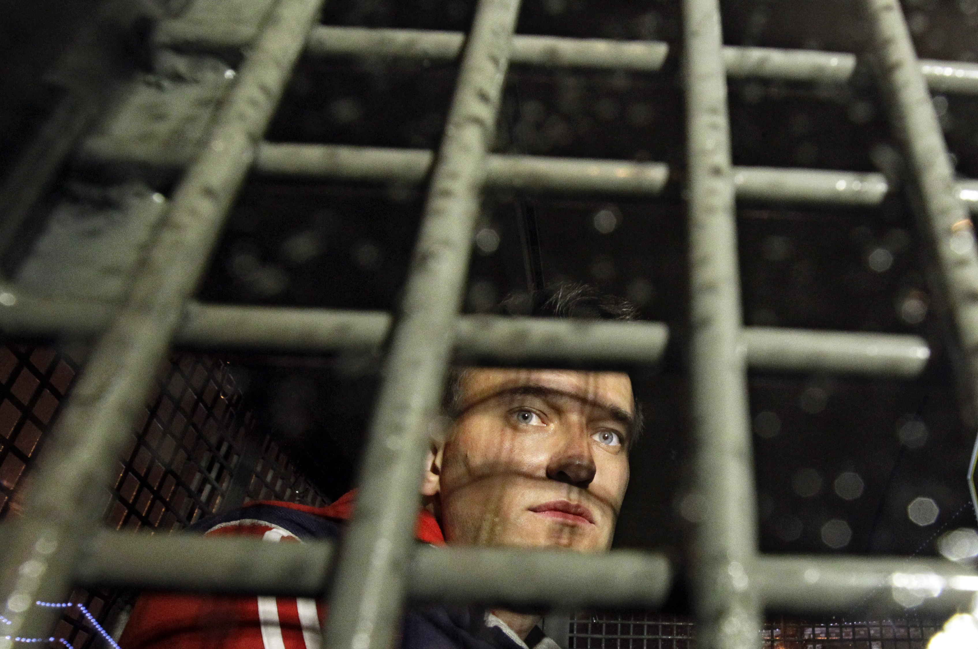 Alexey Navalny is seen behind the bars of a police van in Moscow after he was detained during protests in 2012.