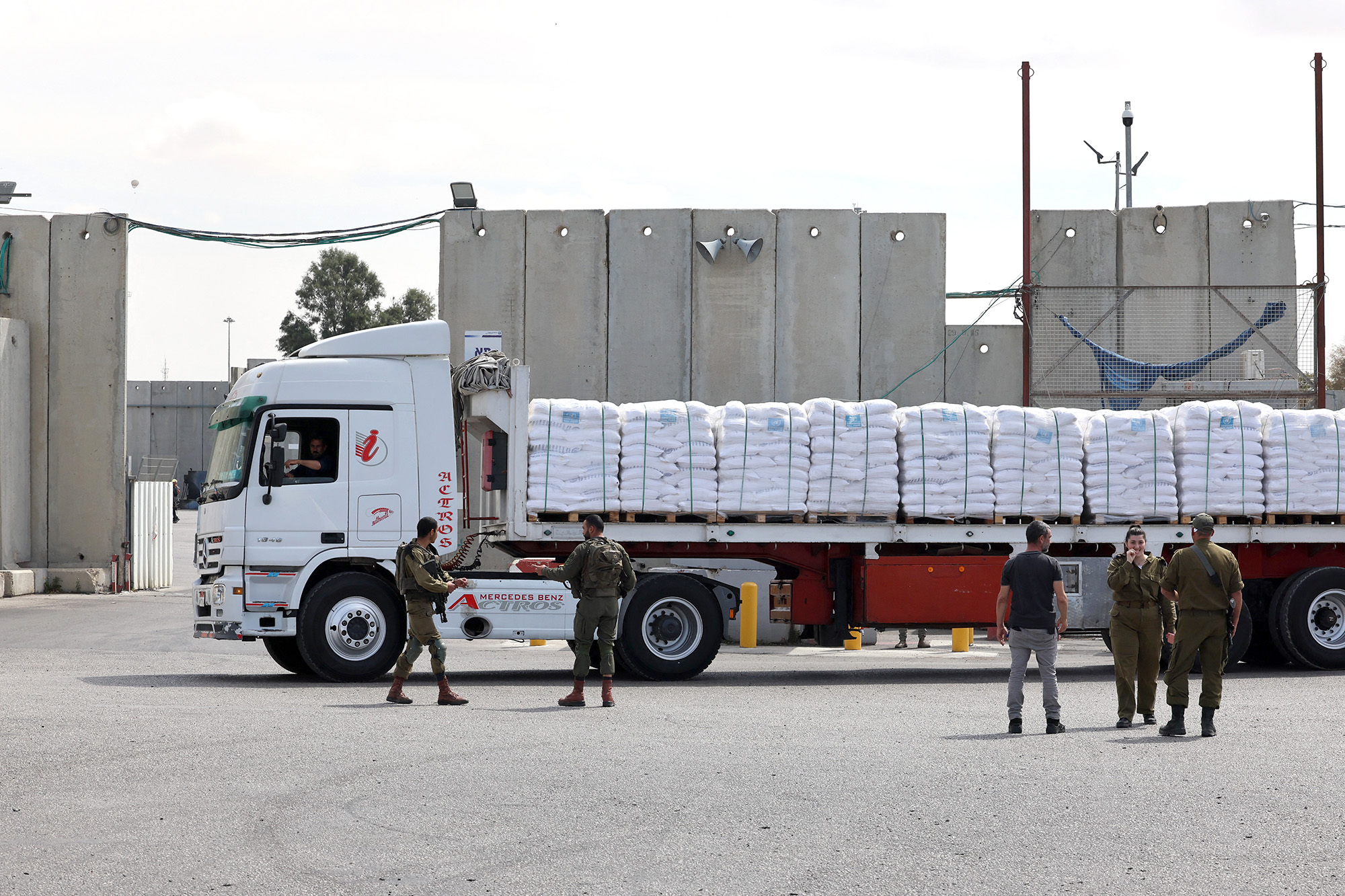 Israeli security forces stand near a truck carrying humanitarian aid slated for Gaza and waiting to be cleared at the Kerem Shalom border crossing on March 14.