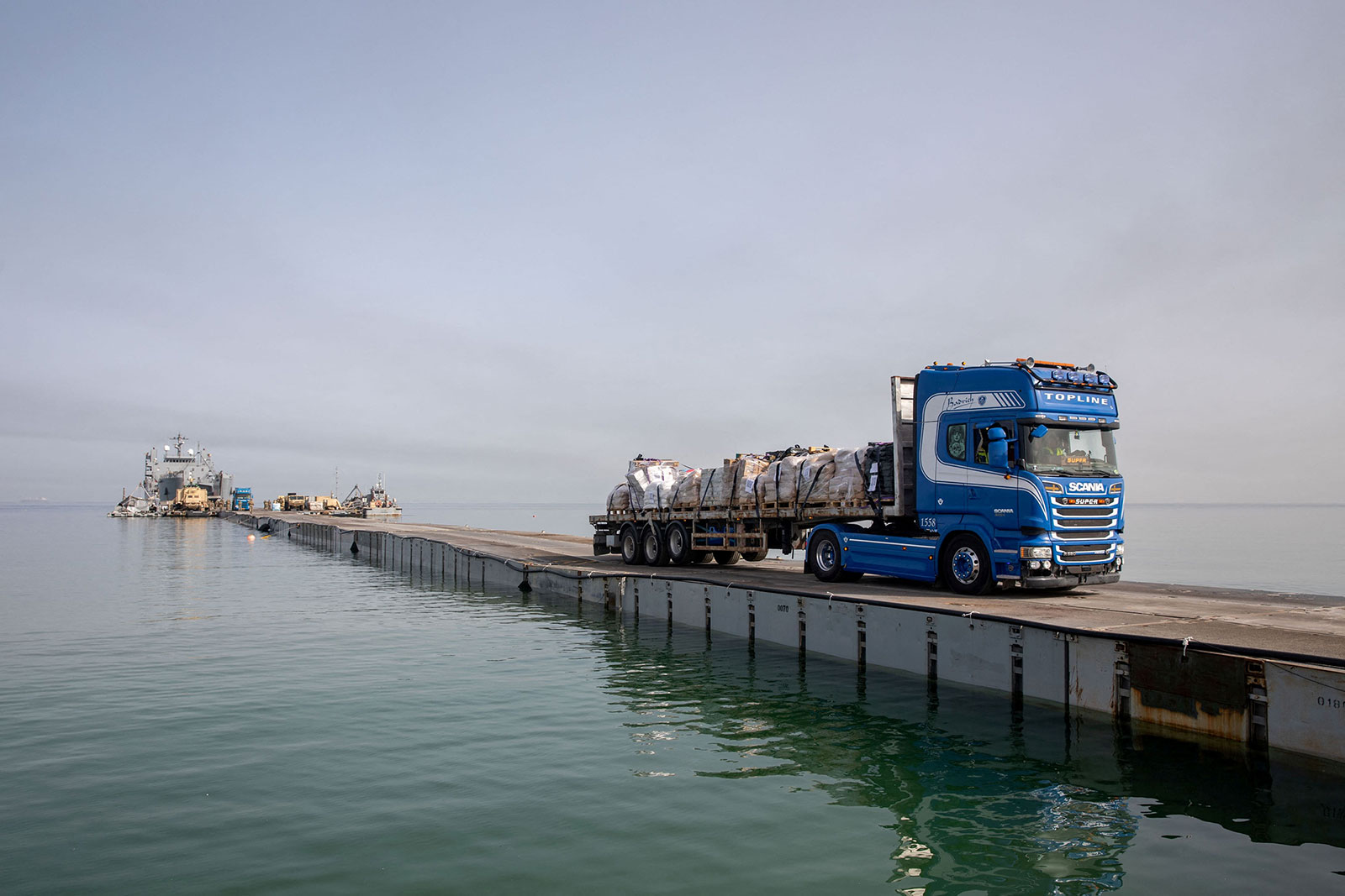 A truck carries humanitarian aid across Trident Pier, a temporary pier to deliver aid, off of Gaza on May 19.