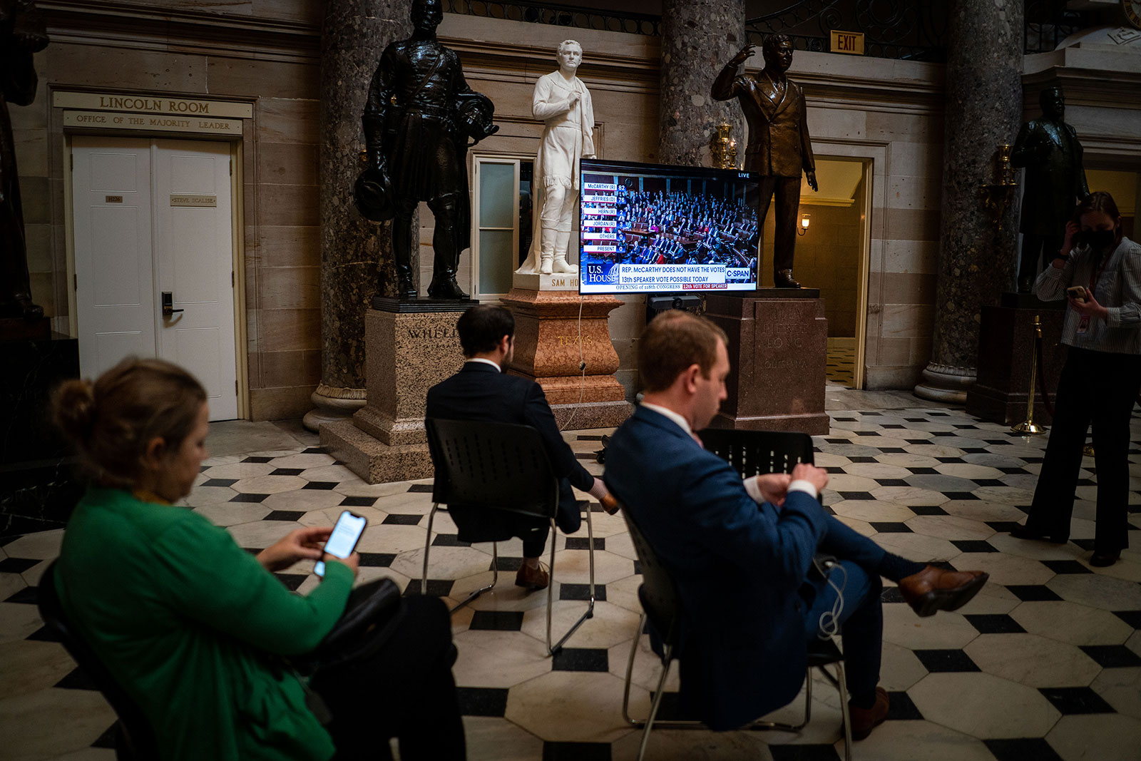 People watch a broadcast of the voting from the Capitol's Statuary Hall.