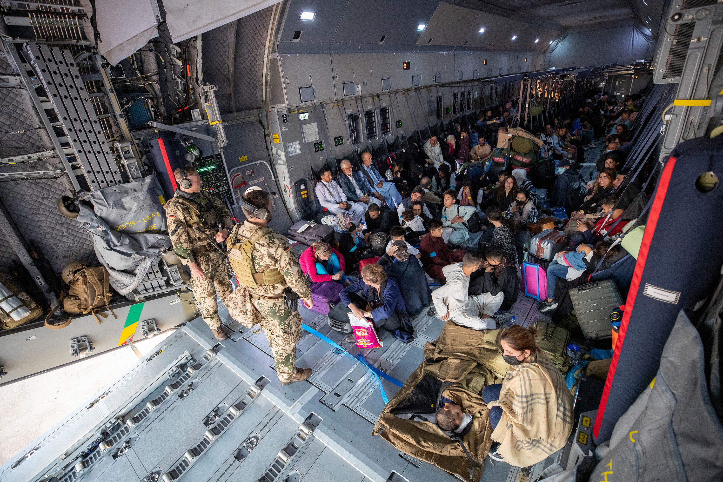 Evacuees from Kabul sit inside a military aircraft in Tashkent, Uzbekistan, on August 17, before reaching their final destination in Germany. 