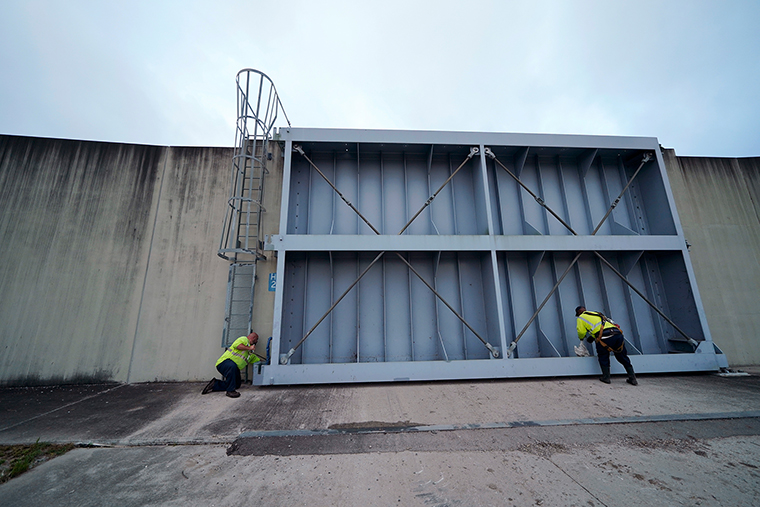 Workers for the Southeast Louisiana Flood Protection Authority-West close floodgates in Harvey, Louisiana, just outside New Orleans, on Monday, Aug. 24, 2020.