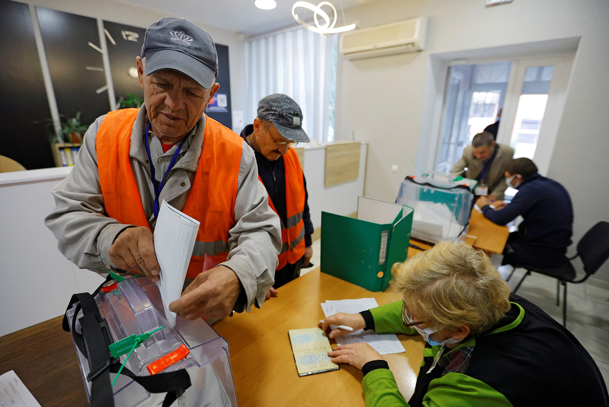 A municipal worker casts his ballot during a referendum on the secession of the Zaporizhzhia region from Ukraine and its joining Russia, in the Russian-controlled city of Melitopol, Ukraine, on September 26.