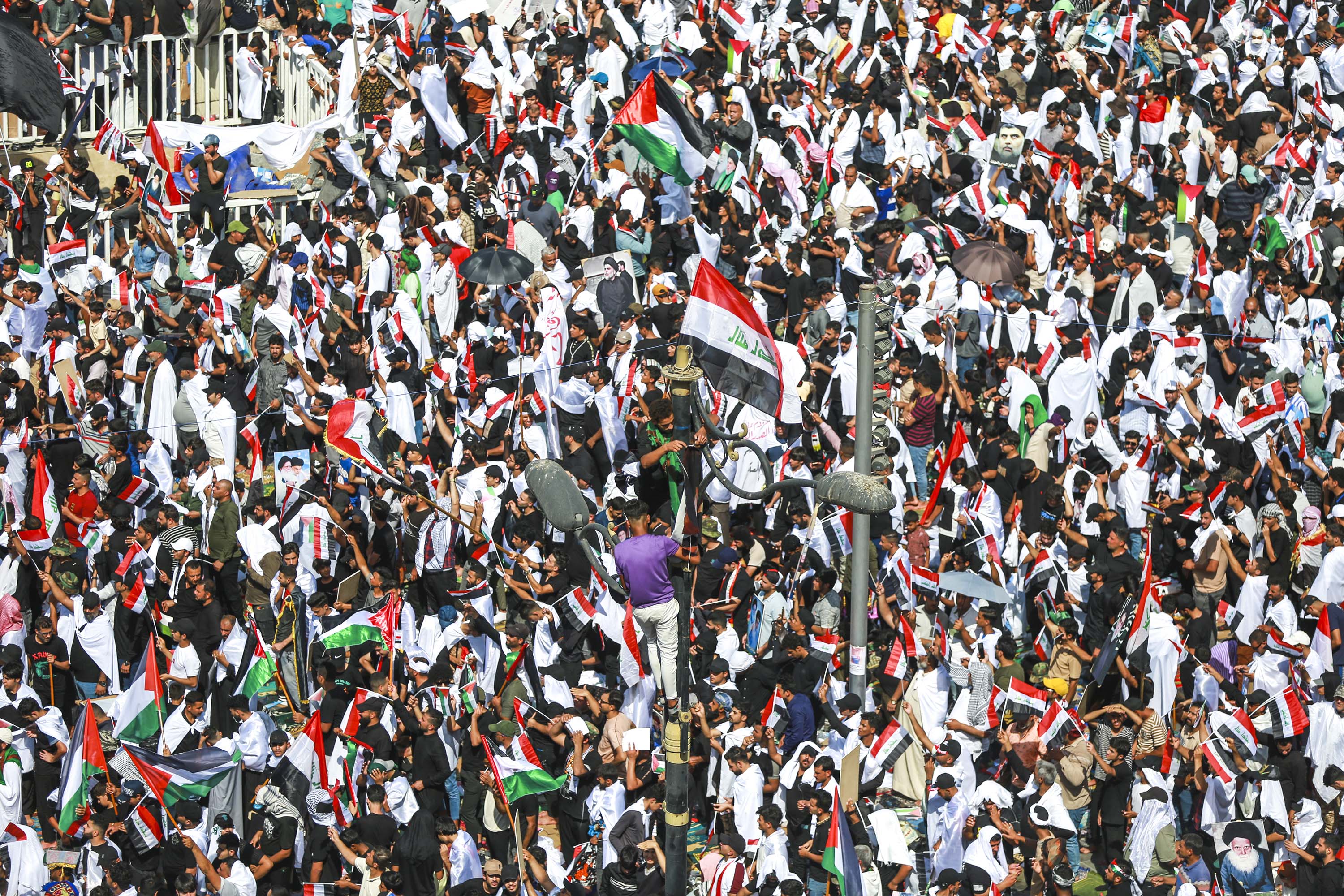People hold a mass rally in support of Palestinians in Gaza, on October 13, in Baghdad, Iraq. 