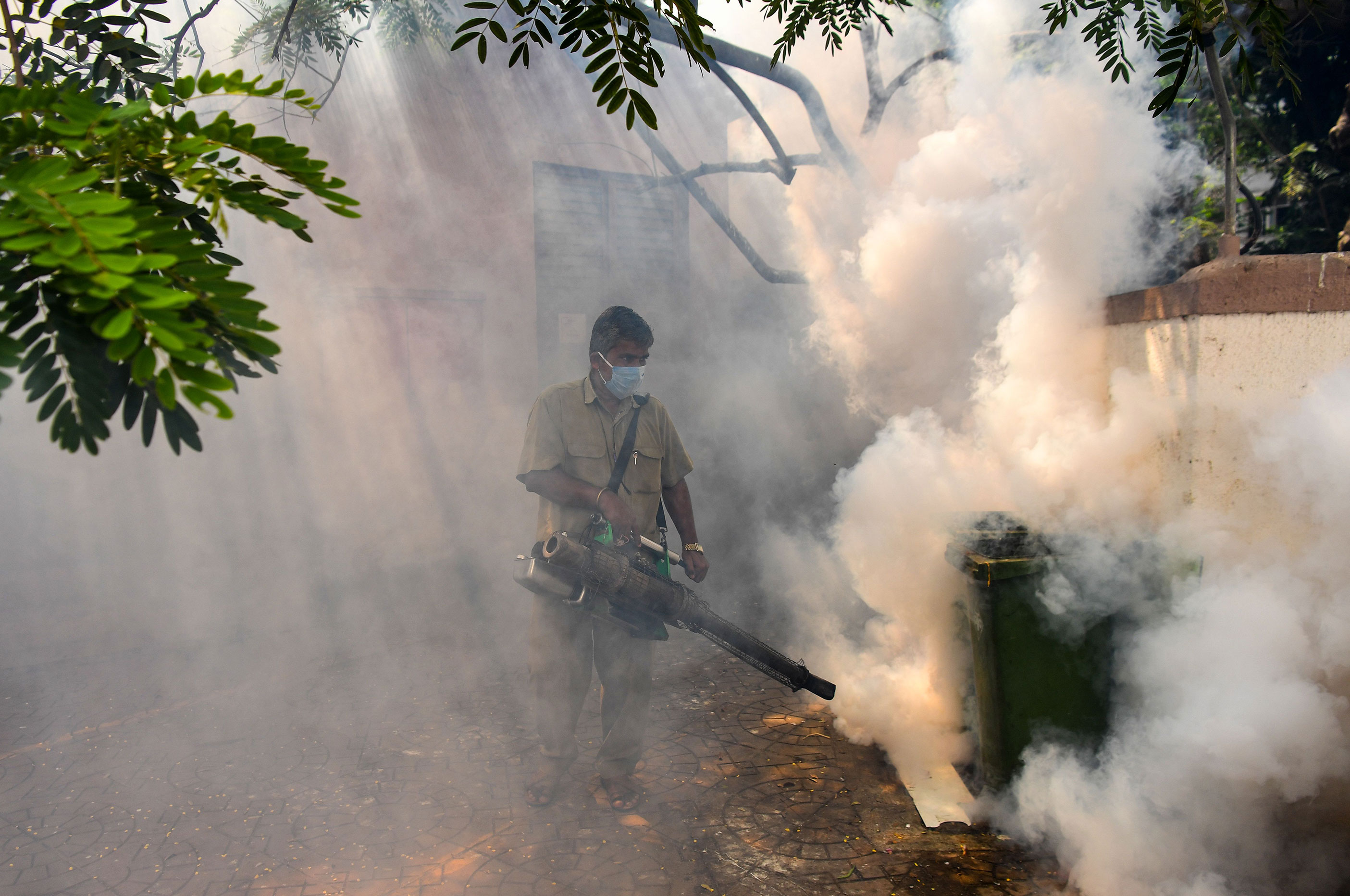 A municipal staff member fumigates a residential building in Navi Mumbai, India on April 22.