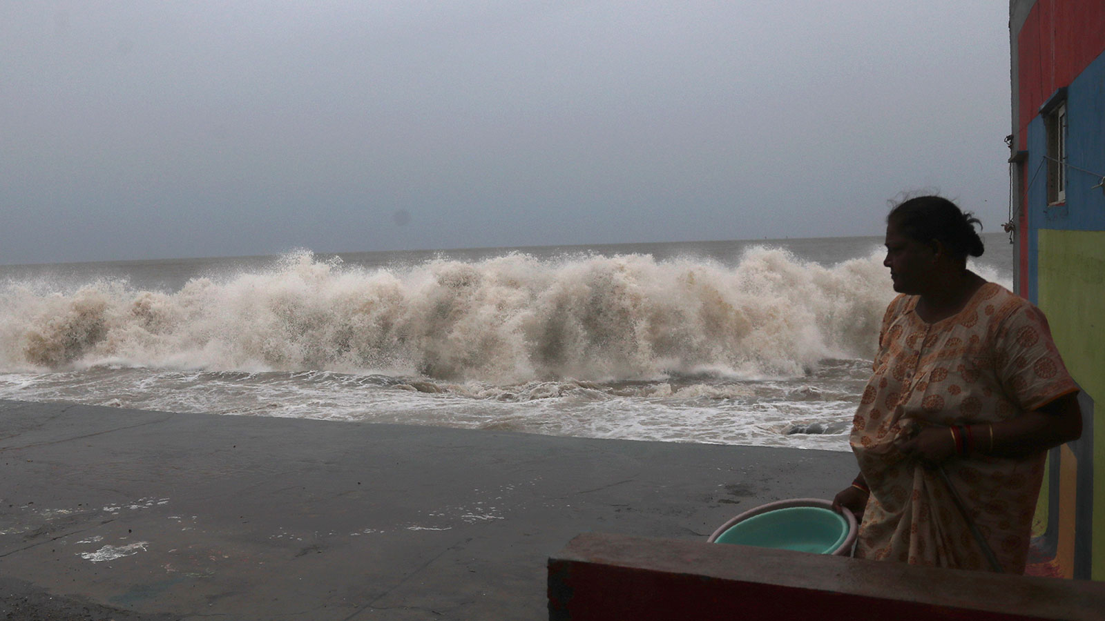 A woman watches waves splash on shores of the Arabian Sea in Mumbai, India on June 3.