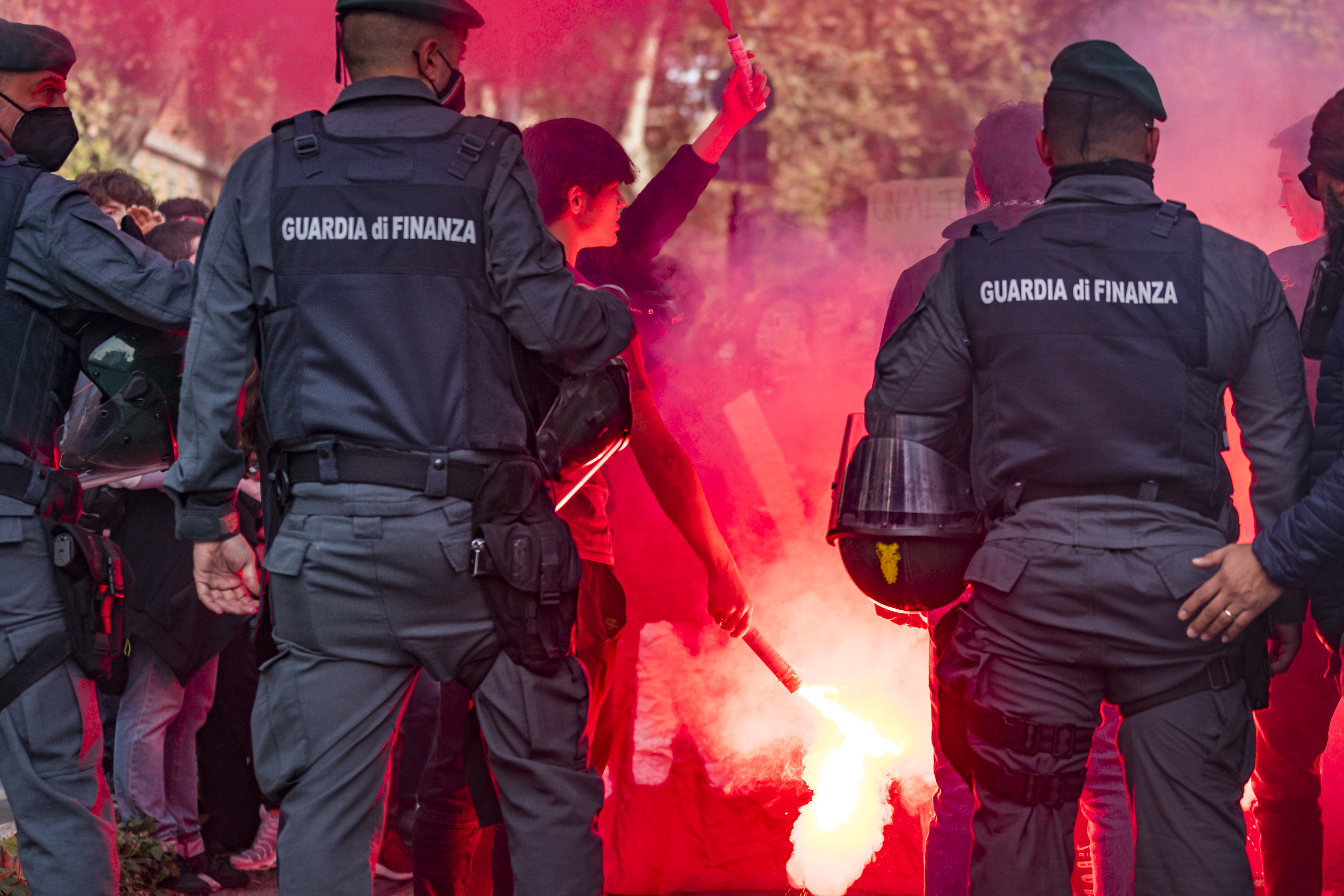 A protester holds a flare in front of the police during a demonstration in Rome during the G20 summit Friday, October 29, 2021.  