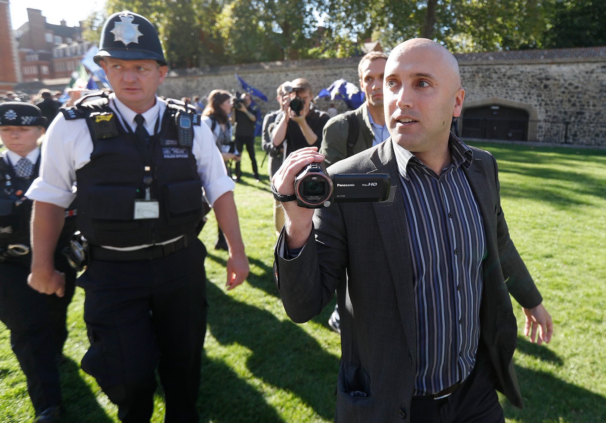 Blogger Graham Phillips is escorted away by police officers after he disrupted a press conference in London on October 9, 2018.