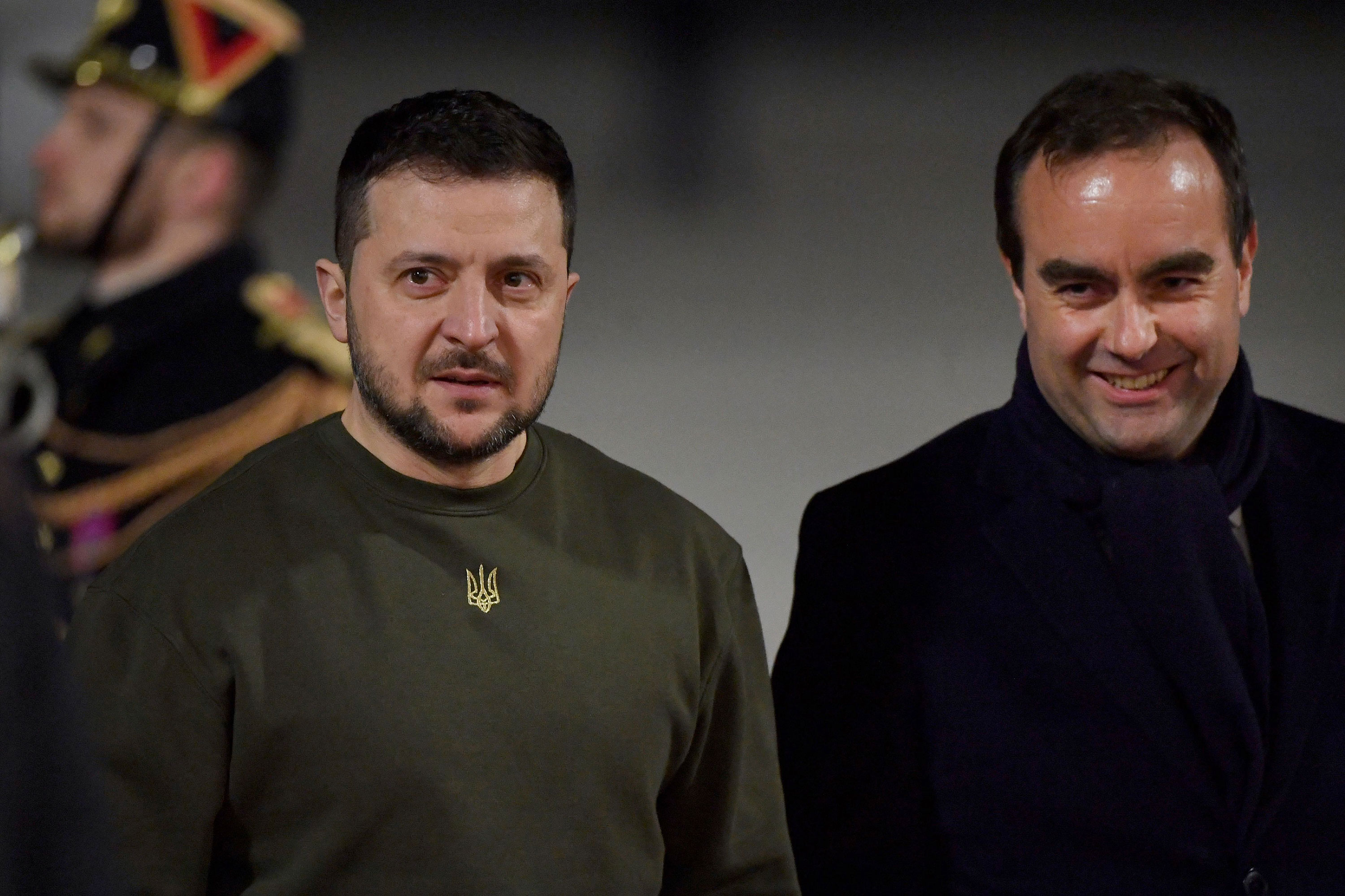 Ukrainian President Volodymyr Zelensky, left, is welcomed by French defense minister Sébastien Lecornu upon his arrival at the Paris Orly airport February 8. 