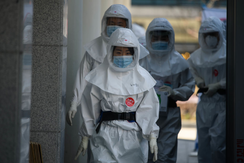 Medical workers walk to a decontamination area at the Keimyung University hospital in Daegu, South Korea, on Friday.