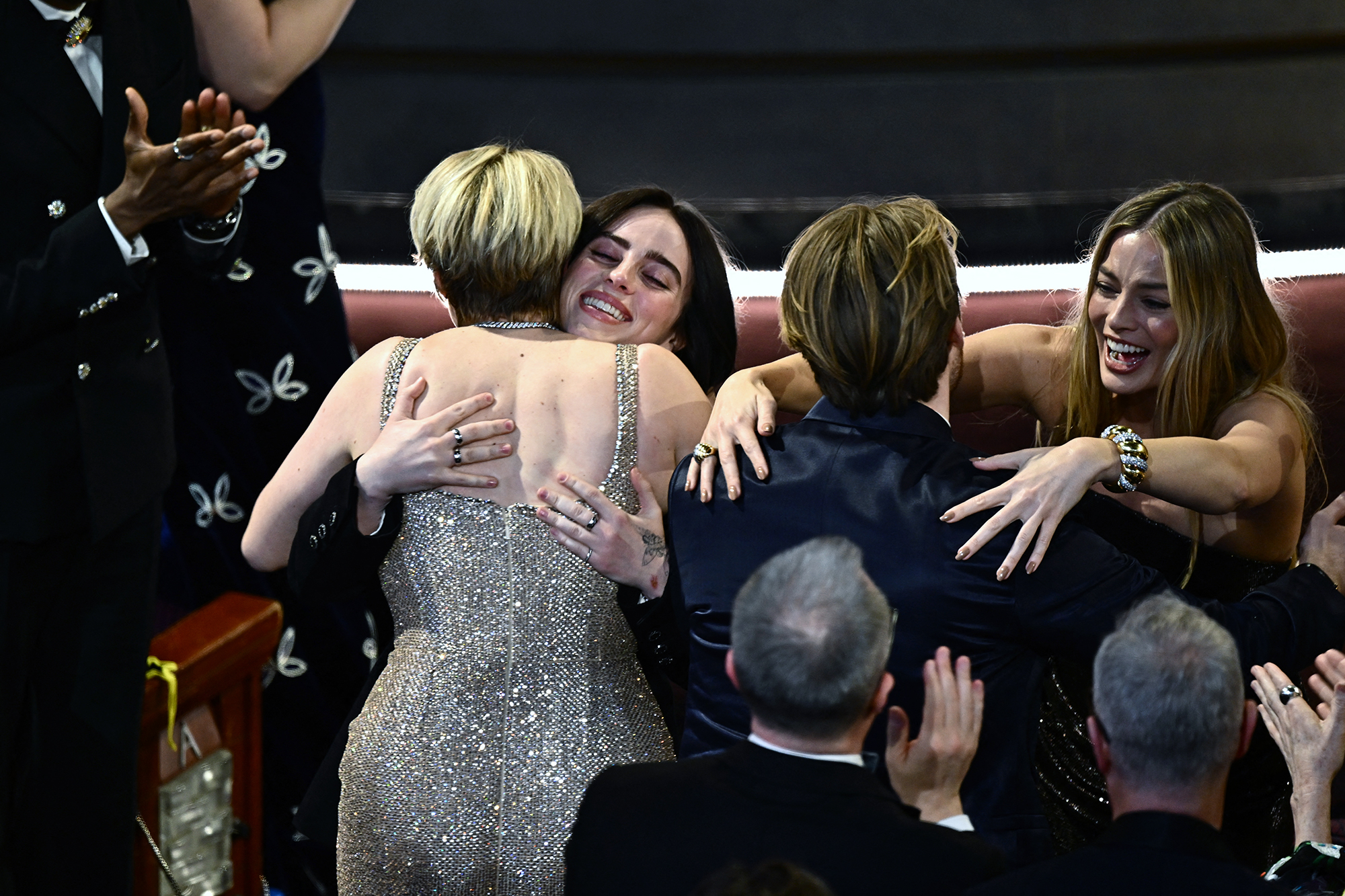 Greta Gerwig and Margot Robbie hug Billie Eilish and Finneas O'Connell after they won the award for best original song for "What Was I Made For" from "Barbie.” 