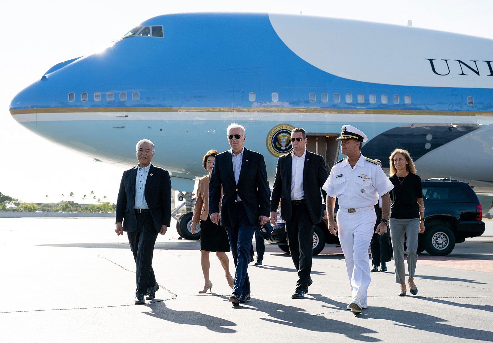 President Joe Biden walks with Hawaii Gov. David Ige, left, and Admiral John C. Aquilino, second right, commander of the United States Indo-Pacific Command, to greet troops at Hickam Air Force Base in Honolulu on November 16 during a refueling stop for Air Force One. Biden returns to Washington, DC, from a week-long trip to Egypt, Cambodia and Indonesia. 