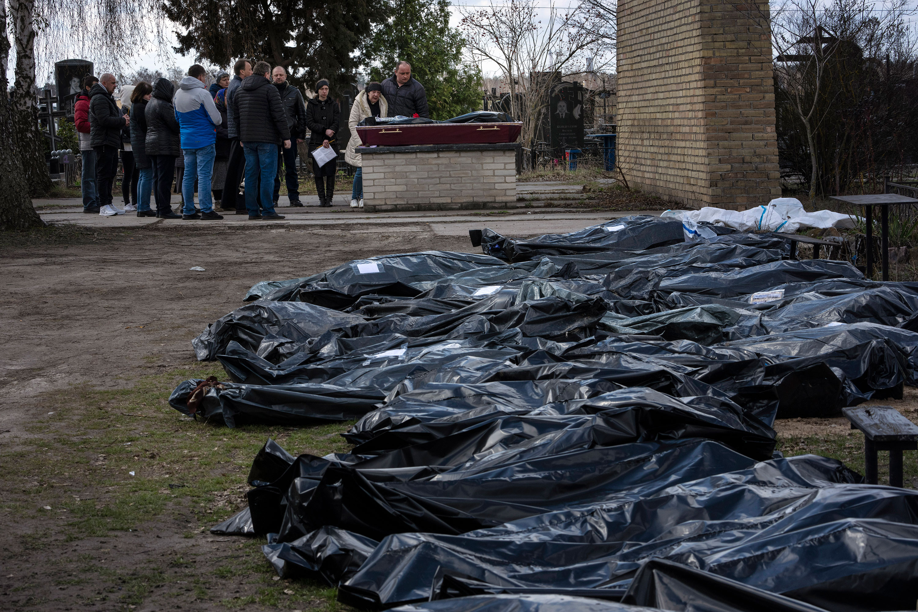 A family mourns a relative killed during the fighting as dozens of black bags containing more bodies lay nearby in a cemetery in Bucha, Ukraine, on April 11.