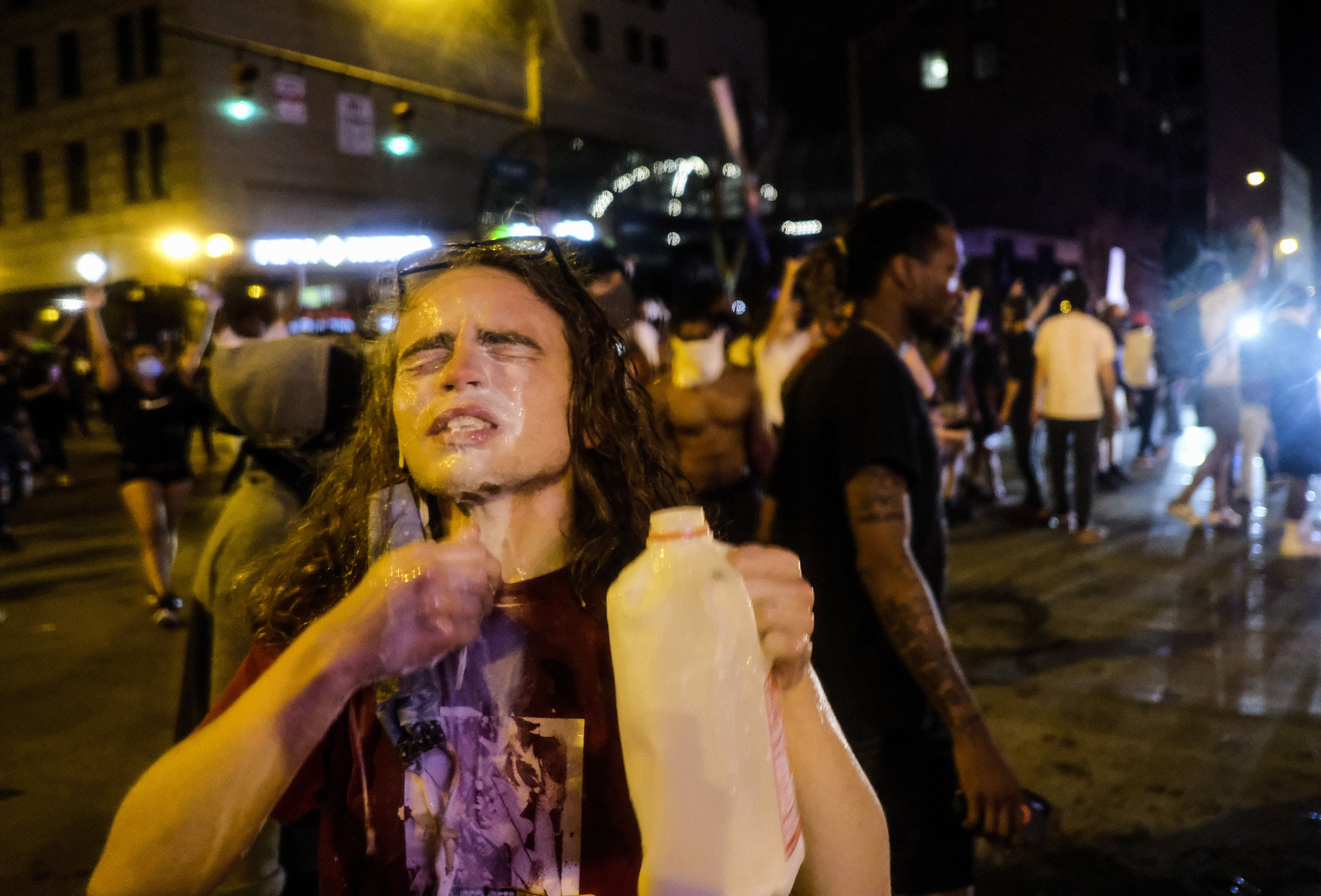 A protester pours what appears to be milk on their face during a demonstration in Columbus, Ohio, on May 28.