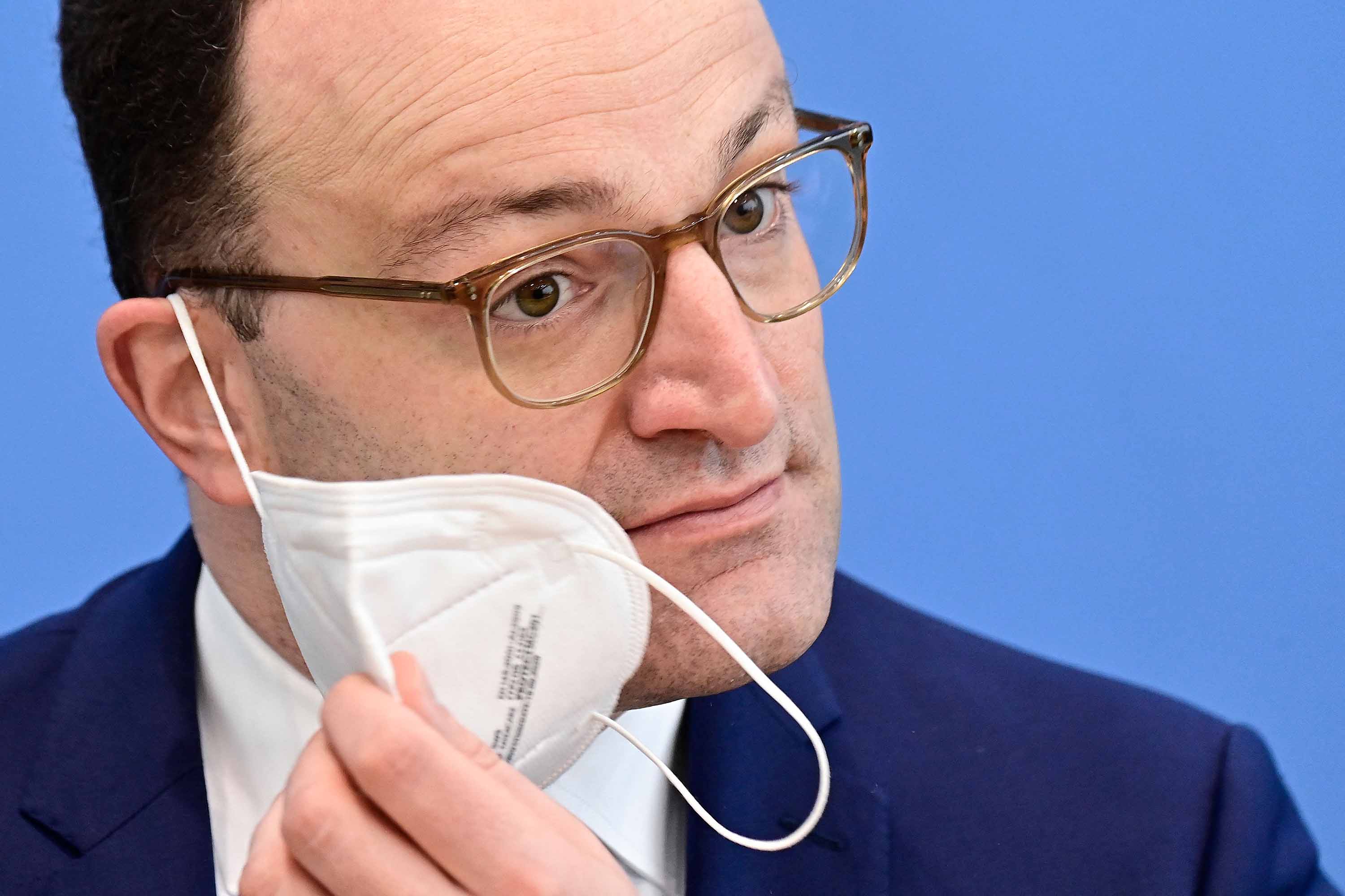 German Health Minister Jens Spahn takes off his face mask before addressing a press conference in Berlin, Germany, on April 23. 