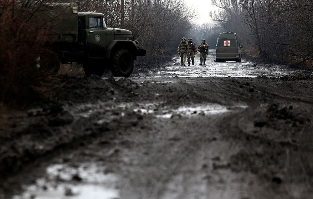 Ukrainian servicemen walk along a muddy road near the frontline town of Bakhmut, Ukraine on Wednesday, March 8. 