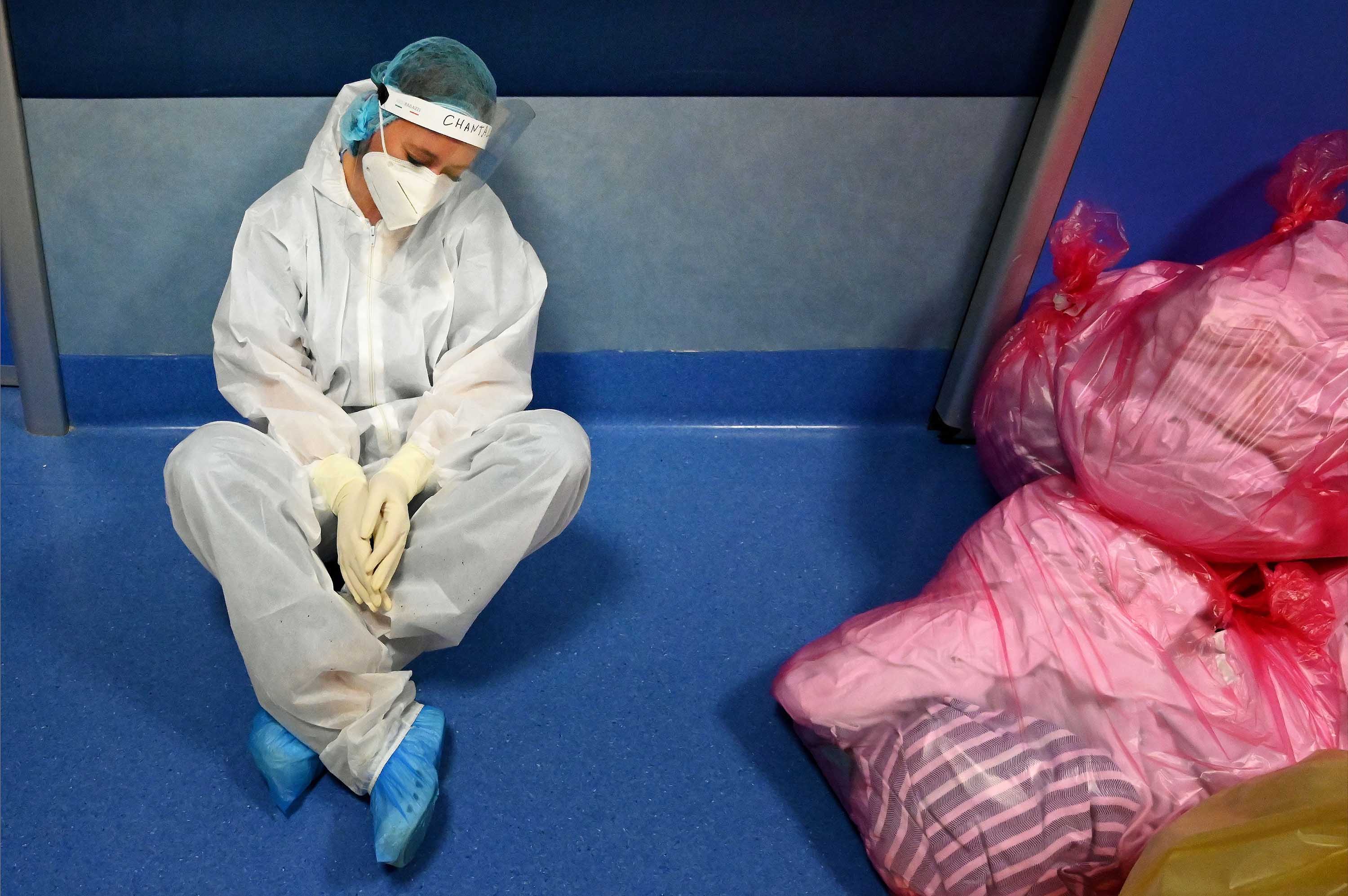 A medical worker rests on the floor in the intensive care unit for novel coronavirus patients at the Casal Palocco hospital, near Rome, on October 22.