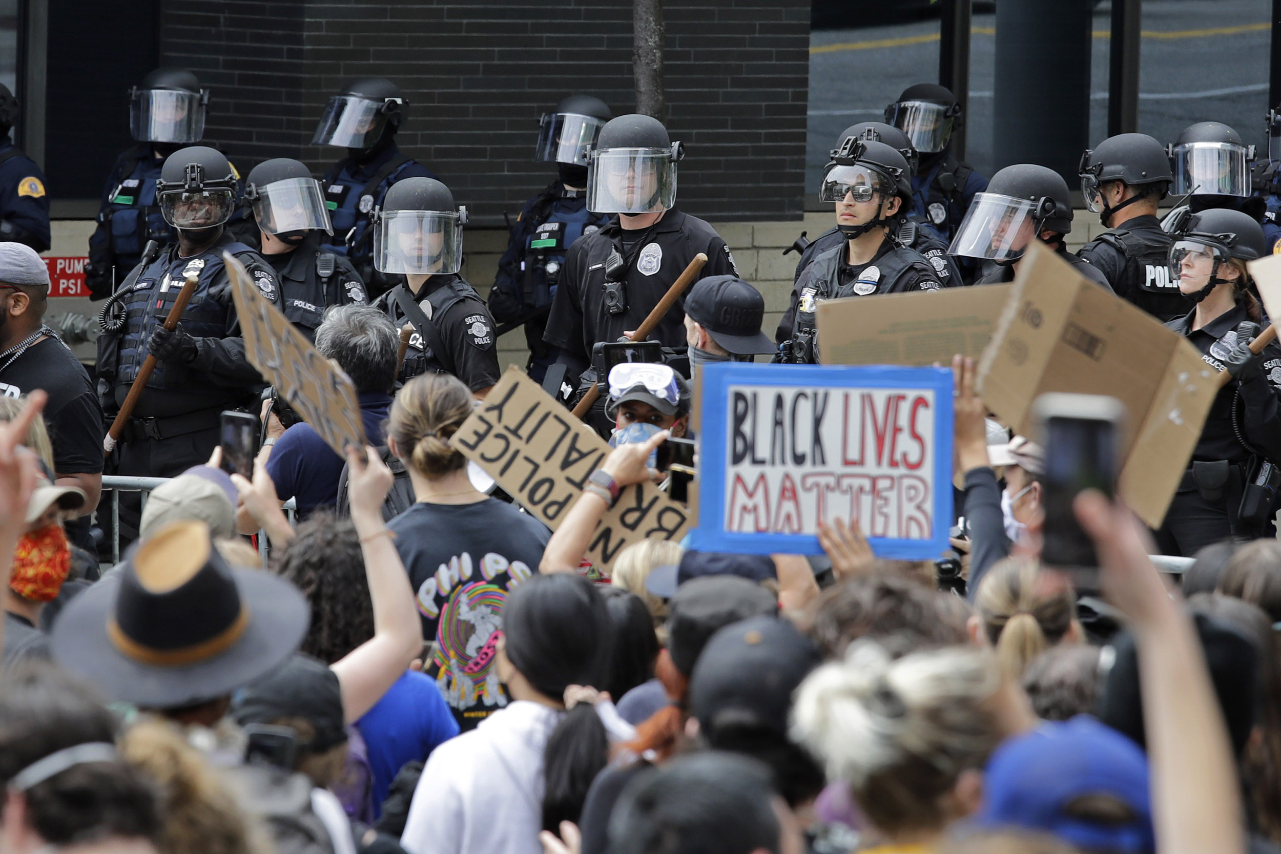 Seattle Police officers watch as protesters fill the street in front of City Hall on Wednesday, June 3, during protests over the death of George Floyd in Minneapolis. 