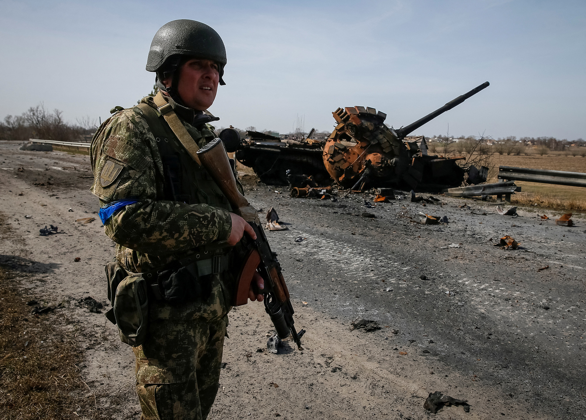 A Ukrainian serviceman stands near the wreck of a Russian tank on the front line in the Kyiv region, Ukraine, on March 28.