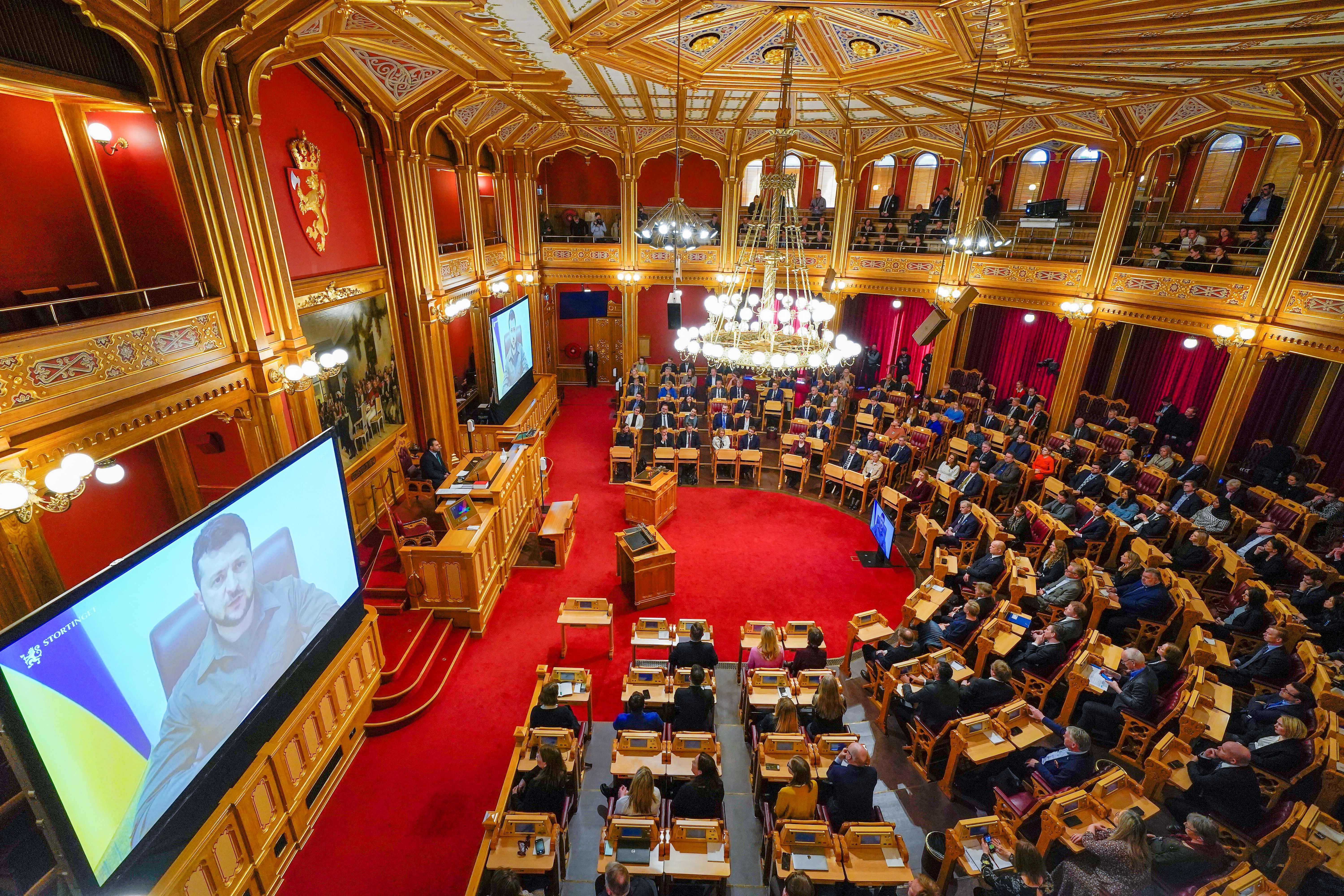 Ukrainian President Volodymyr Zelensky is seen on large screens as he addresses members of Norway's Parliament, The Storting, in Oslo, Norway, on March 30.