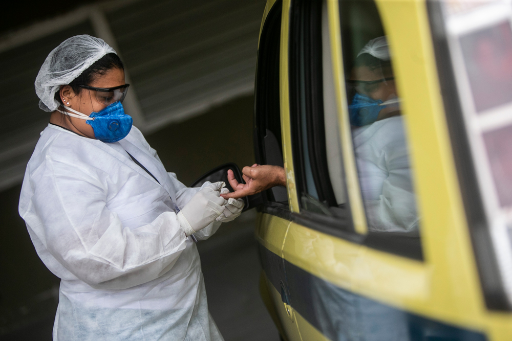 A healthcare worker performs a Covid-19 test to a taxi driver at the Marques de Sapucai Sambadrome on June 15 in Rio de Janeiro.