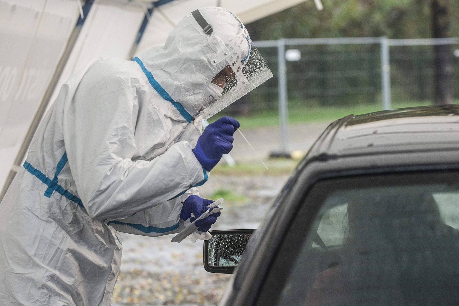 A medical worker takes a sample from a person at a drive-in coronavirus testing station on October 14 in Prague.