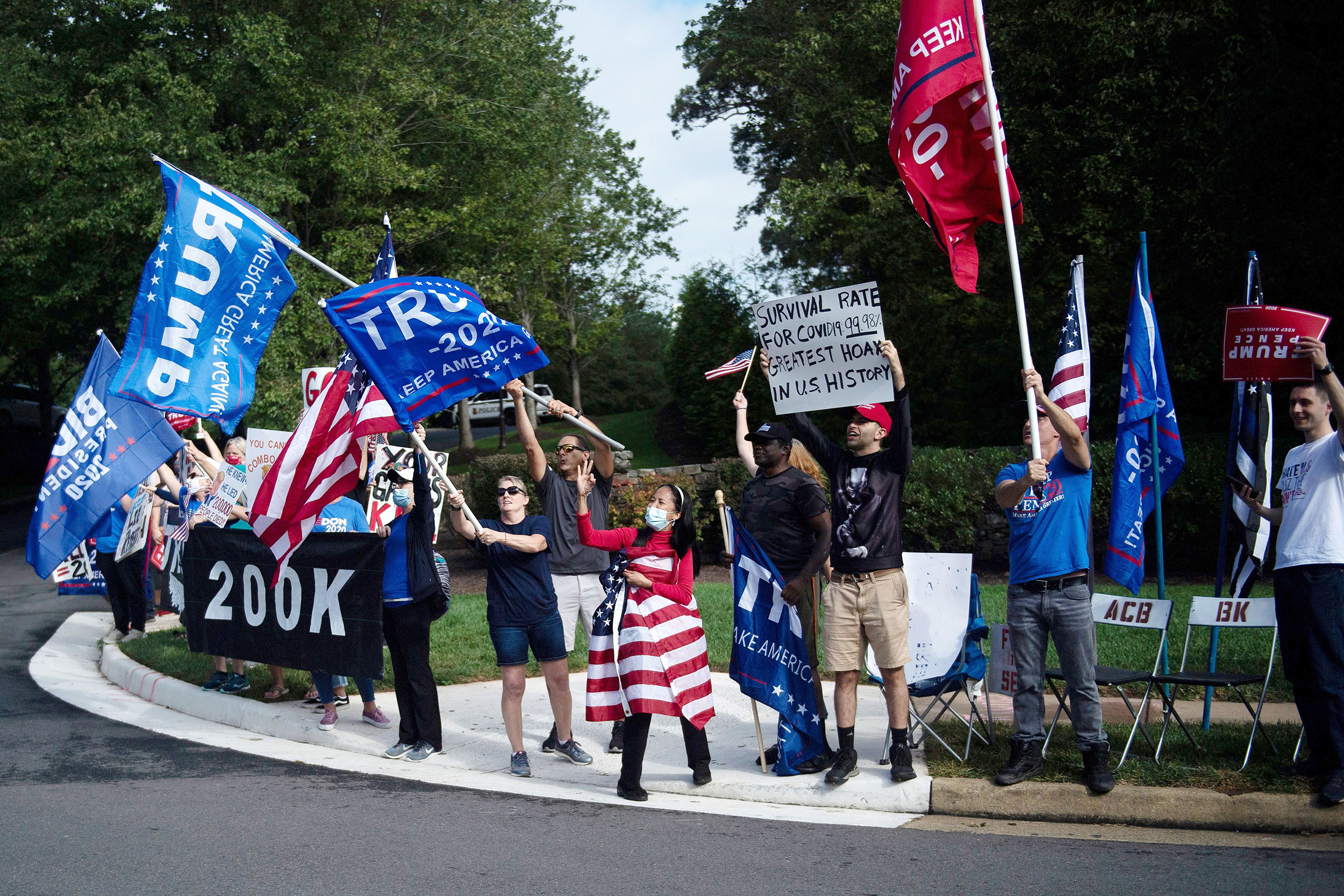 People gather outside the Trump National Golf Club as President Donald Trump arrives on September 27 in Sterling, Virginia. 