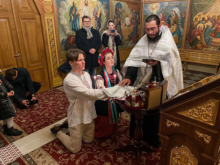 Sviatoslav Fursin, left, and Yaryna Arieva kneel during their wedding ceremony at St. Michael's cathedral in Kyiv on Thursday.