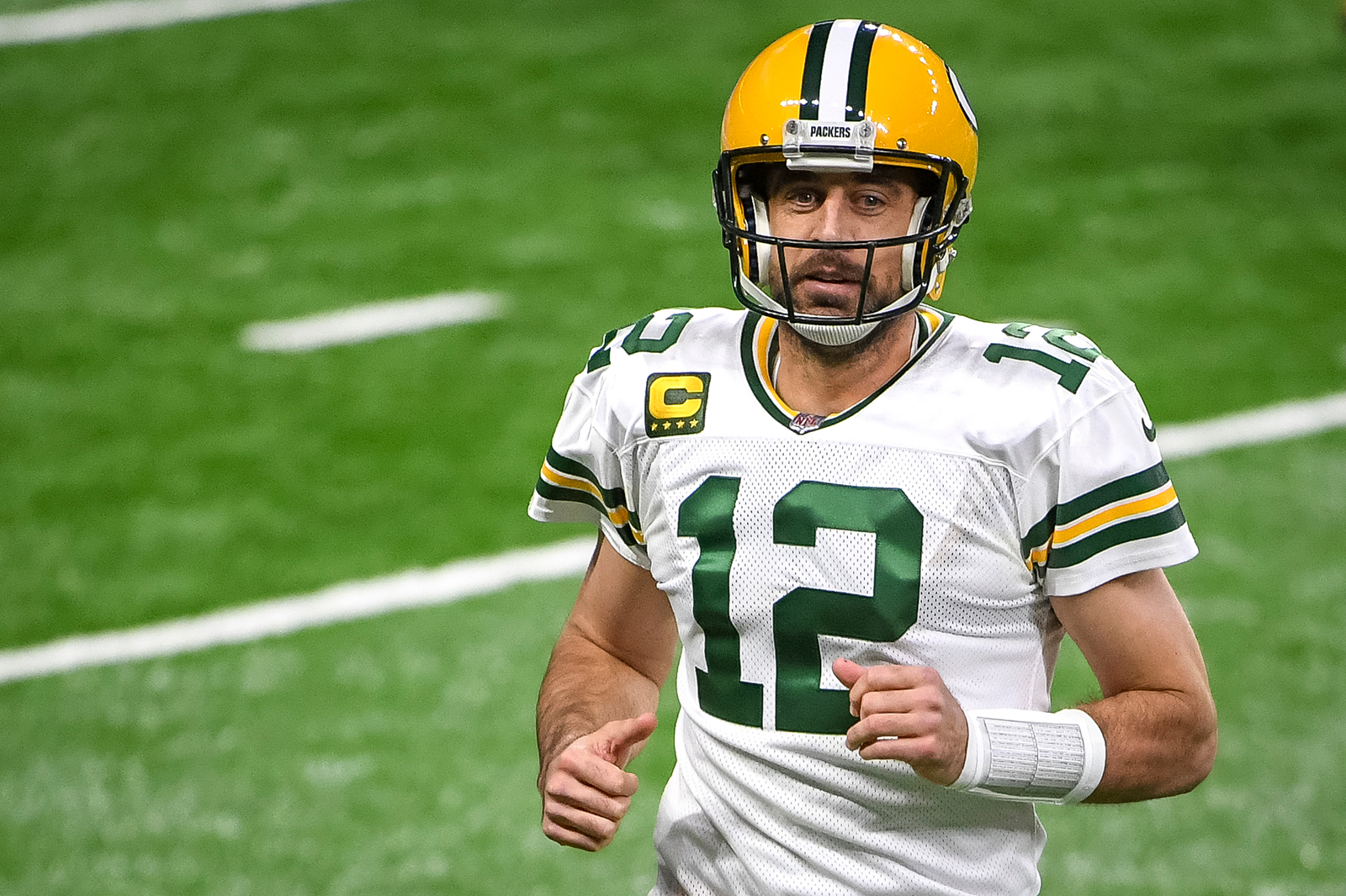 Aaron Rodgers #12 of the Green Bay Packers runs off the field during the first half against the Detroit Lions at Ford Field in Detroit, on December 13, 2020.