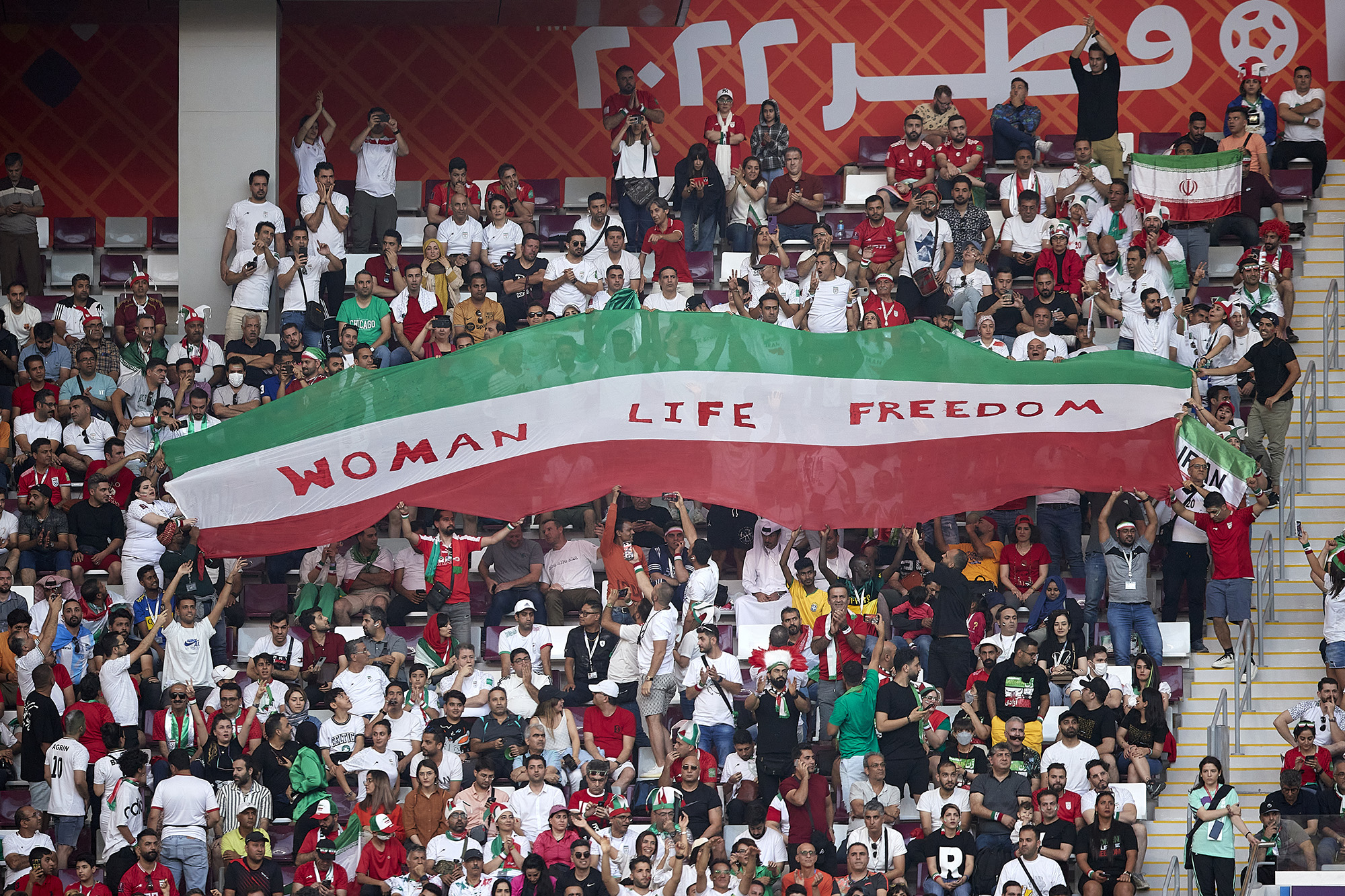 Iranian fans hold up signs "Woman Life Freedom" during their country's match against England in Doha.