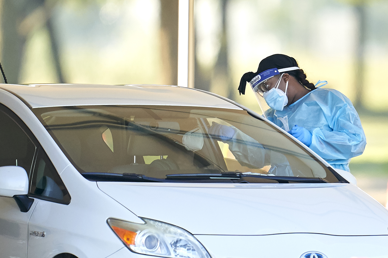 A healthcare worker performs a swab test on a person at a Covid-19 drive-through testing site in Mesquite, Texas, on Tuesday, August 18.