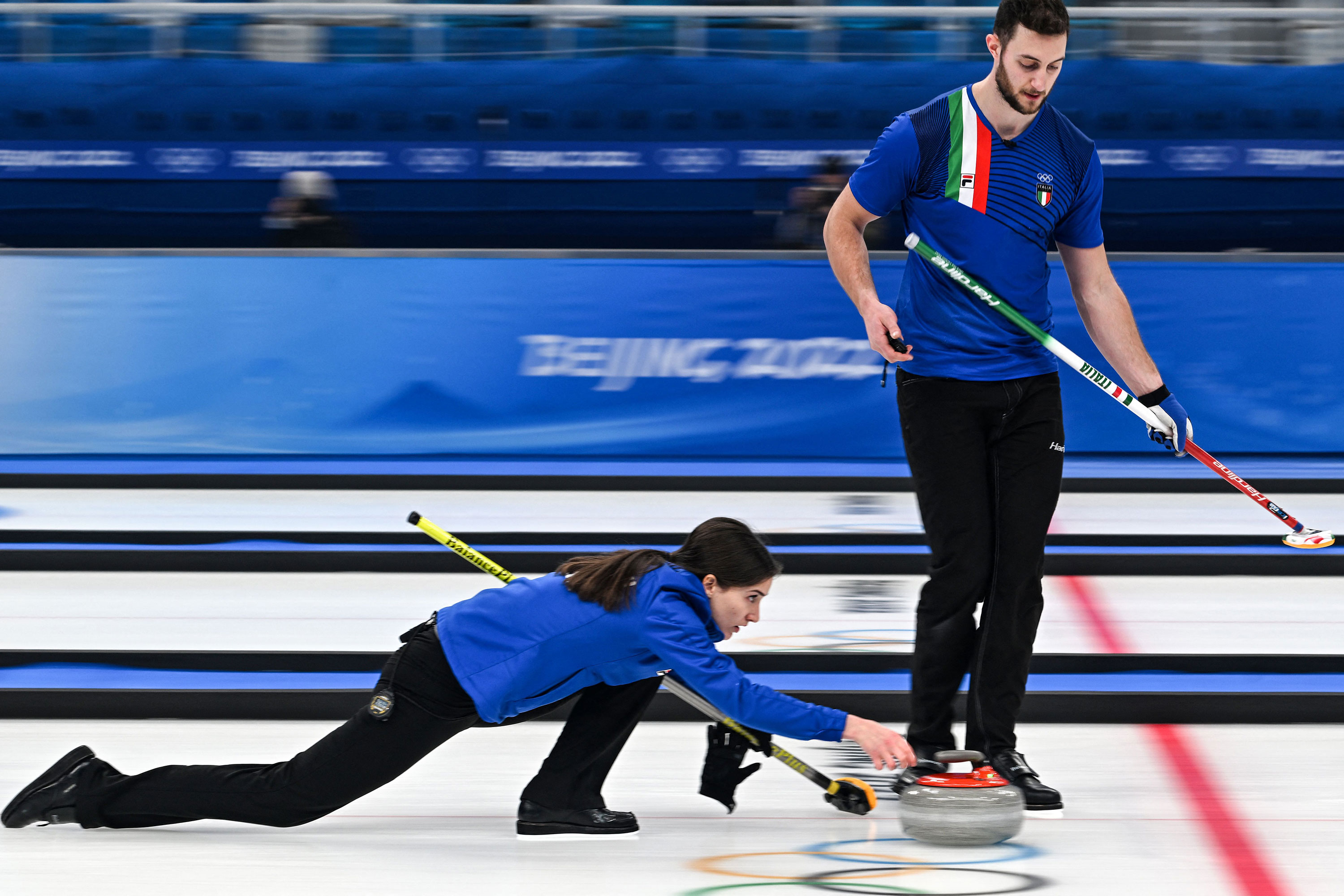 Italy's Stefania Constantini, left, and Amos Mosaner curl the stone during the mixed doubles gold medal game on Tuesday. 