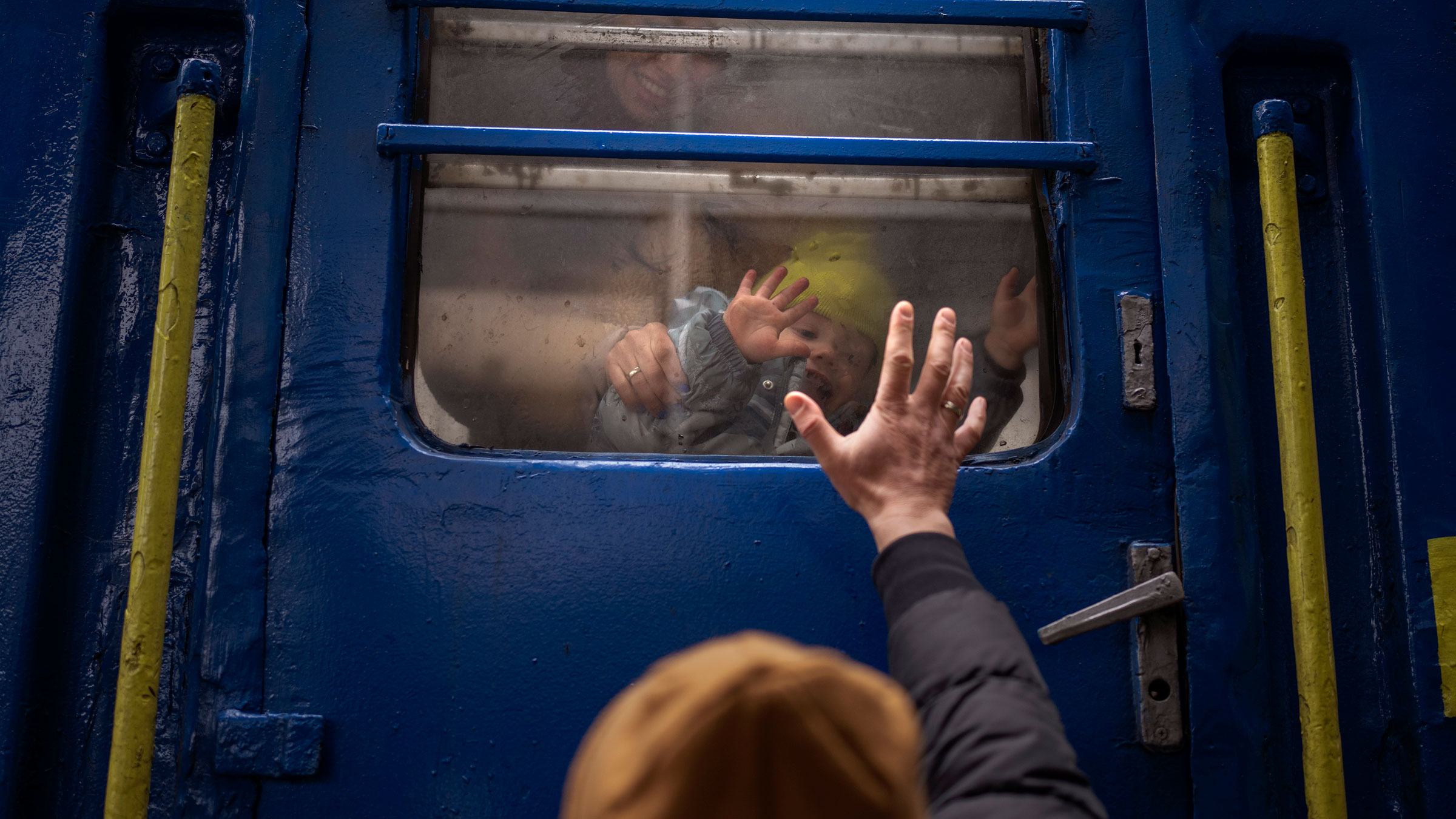A man says goodbye to his wife and son at a train station in Kyiv, Ukraine, on Thursday. He was staying behind to fight while his family was leaving to seek refuge in a neighboring country. 