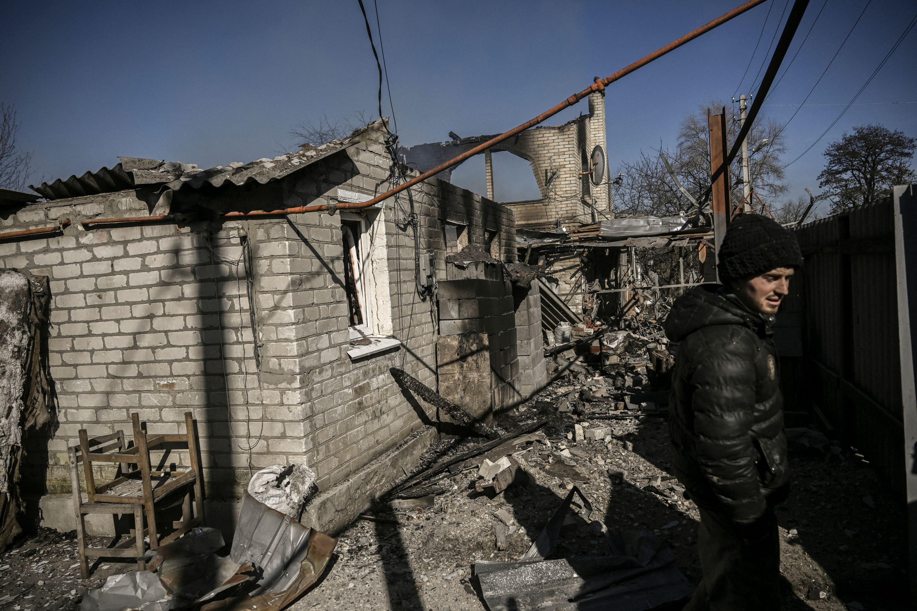 A man stands in front of a house destroyed by shelling in the village of Chasiv Yar near Bakhmut, on March 14.