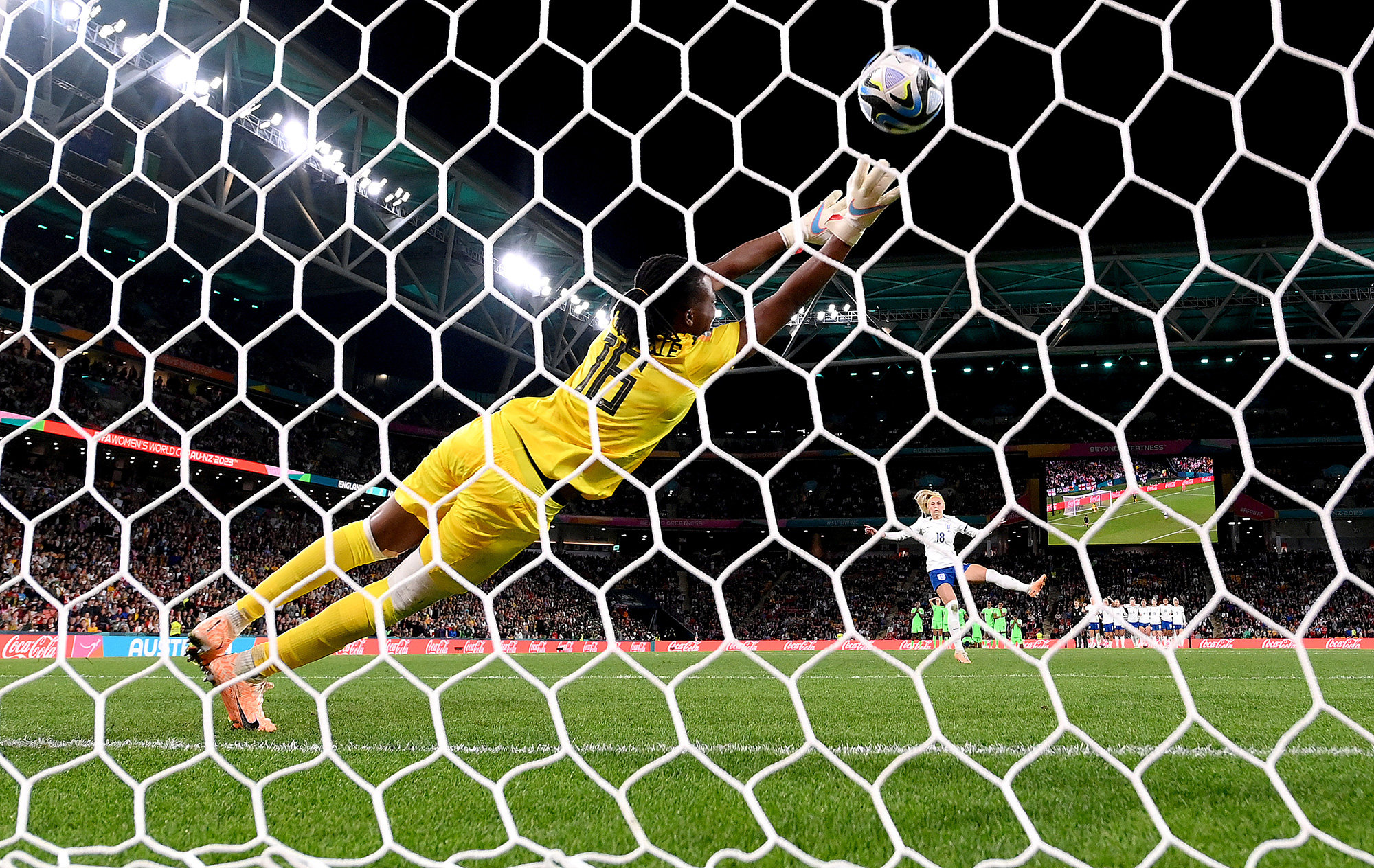 Nigeria's Chiamaka Nnadozie dives in vain as England's Chloe Kelly scores the winning goal in the penalty shootout.