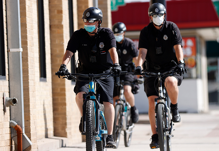 Denver Police Department officers wear face masks as they patrol on their bicycles on Wednesday, April 22.