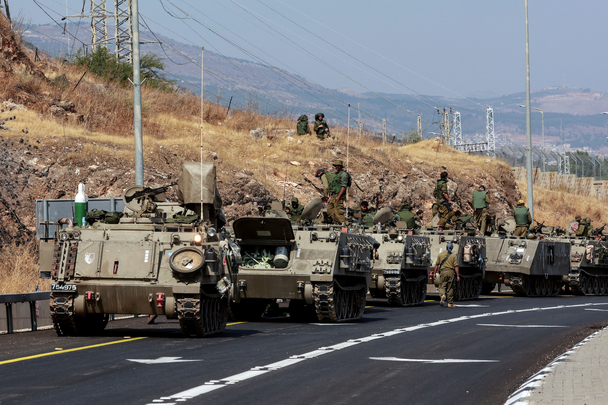 A convoy of Israeli armored vehicles drive on a road near Israel's border with Lebanon on Monday.