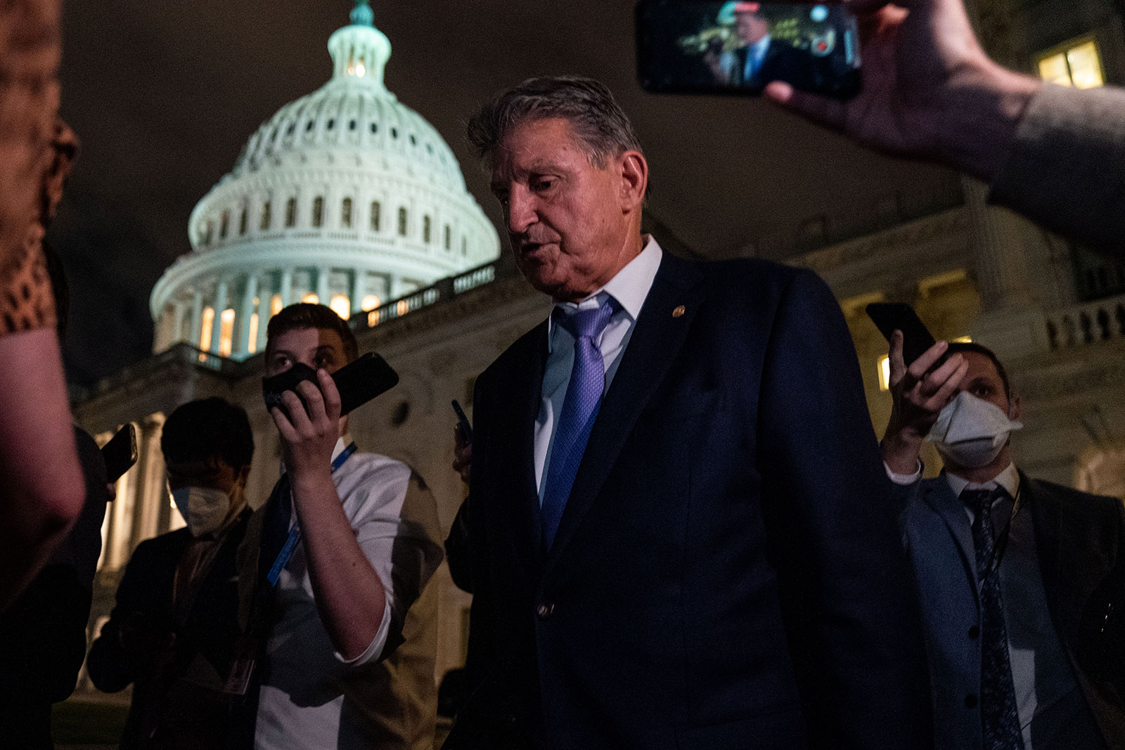 Sen. Joe Manchin walks with reporters outside the US Capitol on September 30.