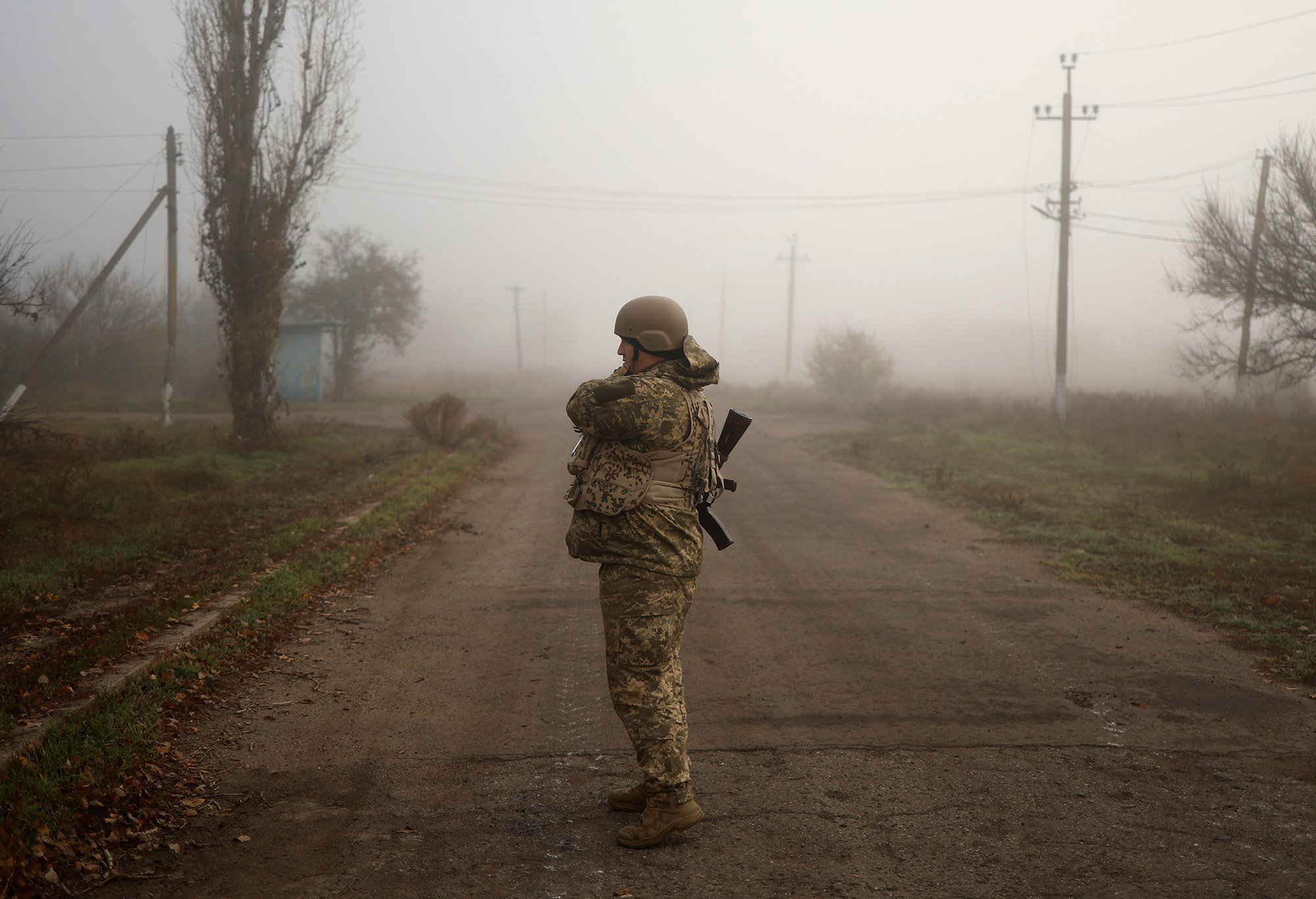 A Ukrainian serviceman stands on a street in a village near the newly recaptured city of Snihurivka, in the Mykolaiv region, Ukraine, on November 10.