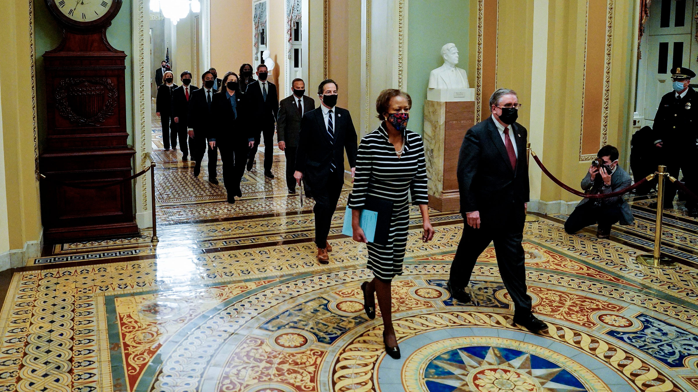 House impeachment managers are lead through the Capitol to deliver the article of impeachment against former President Donald Trump to the Senate floor on January 25, in Washington, DC. 