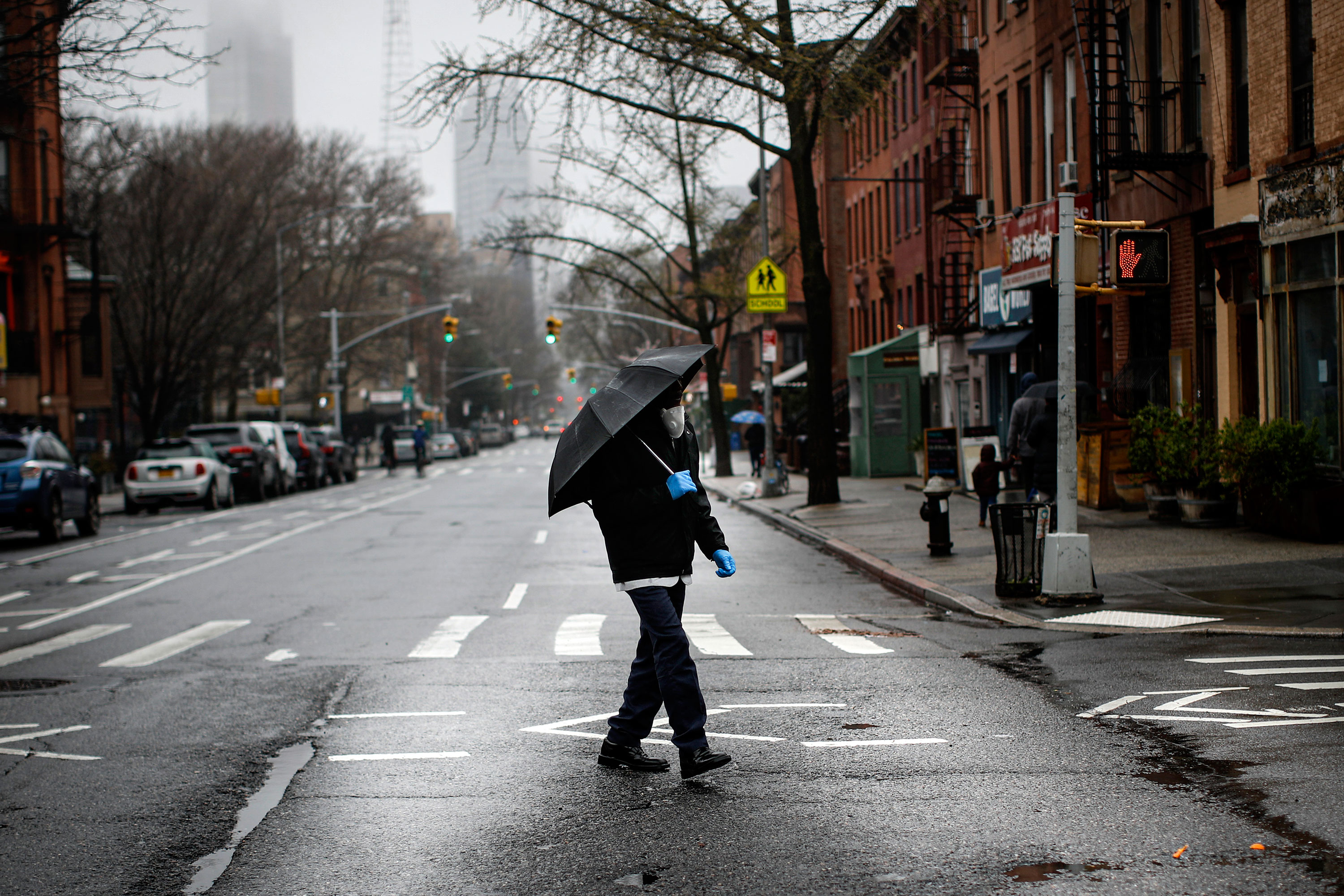 A pedestrian walks across an empty Dekalb Avenue in Brooklyn borough of New York on March 29.