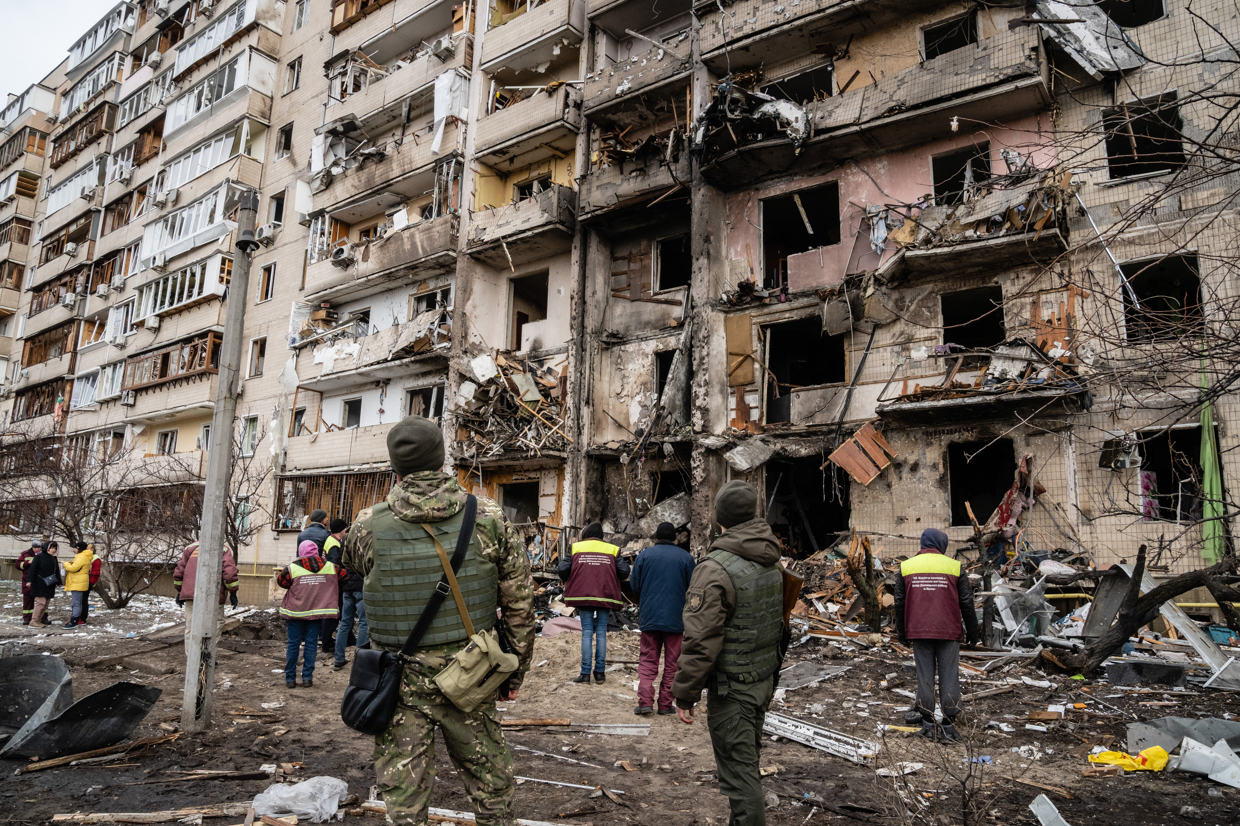 Onlookers at a devastated apartment block in Kyiv after an airstrike on February 25.