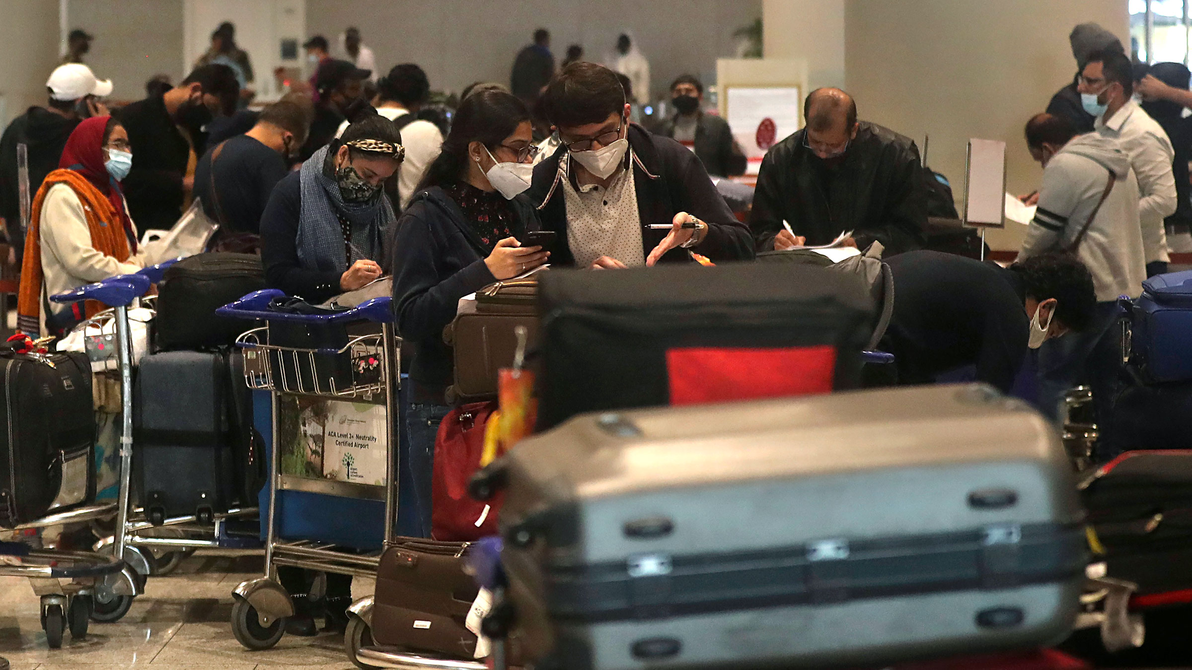 Passengers arriving from United Kingdom fill in forms with their travel details at Chhatrapati Shivaji Maharaj International Airport in Mumbai, India, on December 22, 2020. 