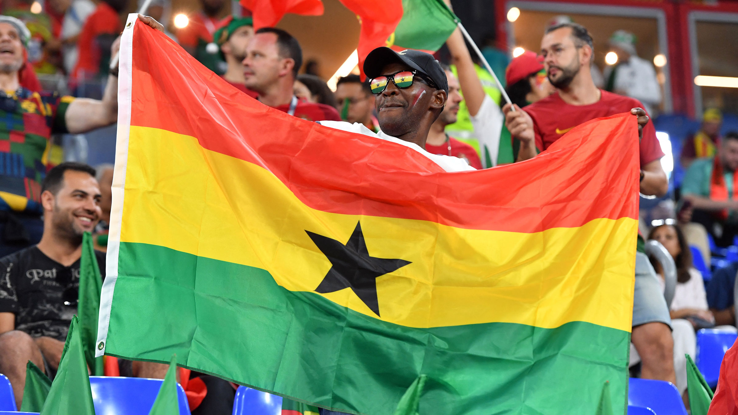 A Ghana fan holds up a flag inside the stadium.